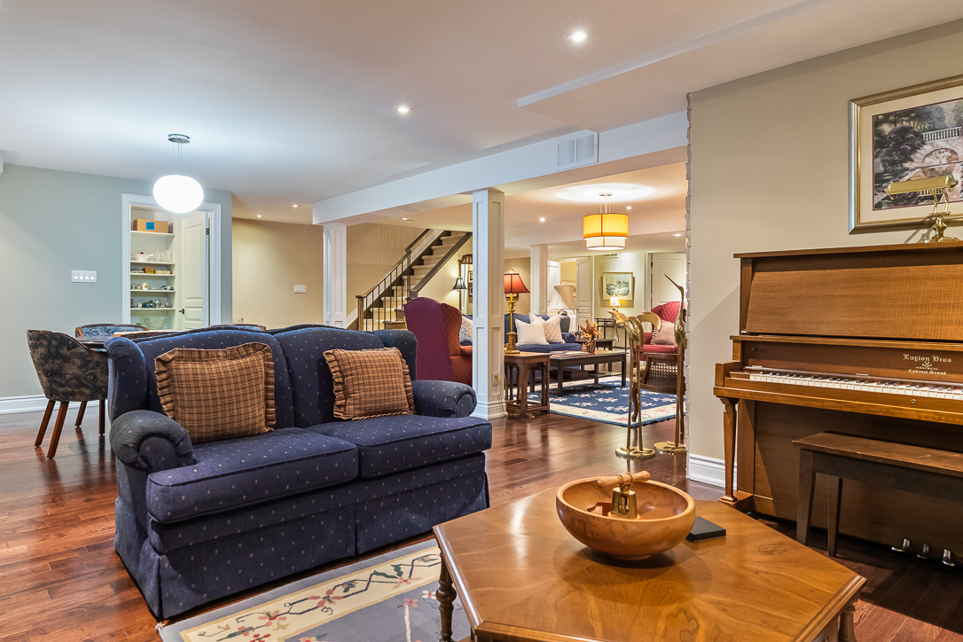 Cozy living room with a blue sofa, piano, and wooden coffee table