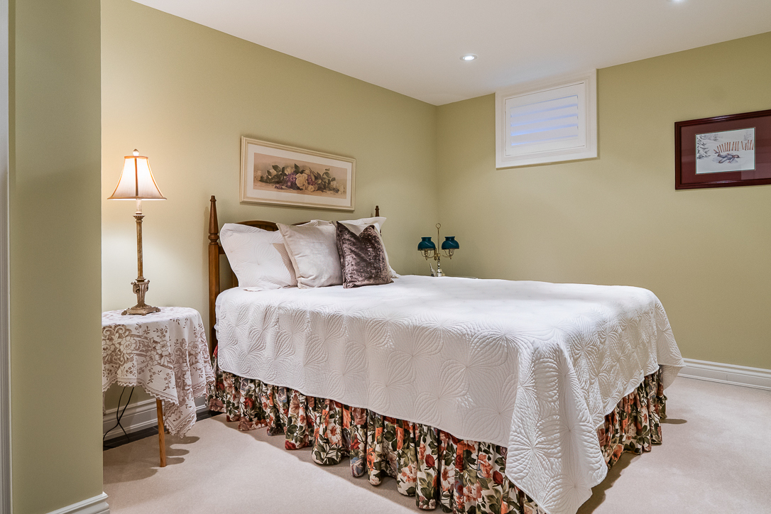 Cozy bedroom with a double bed, floral bedskirt, and soft lighting