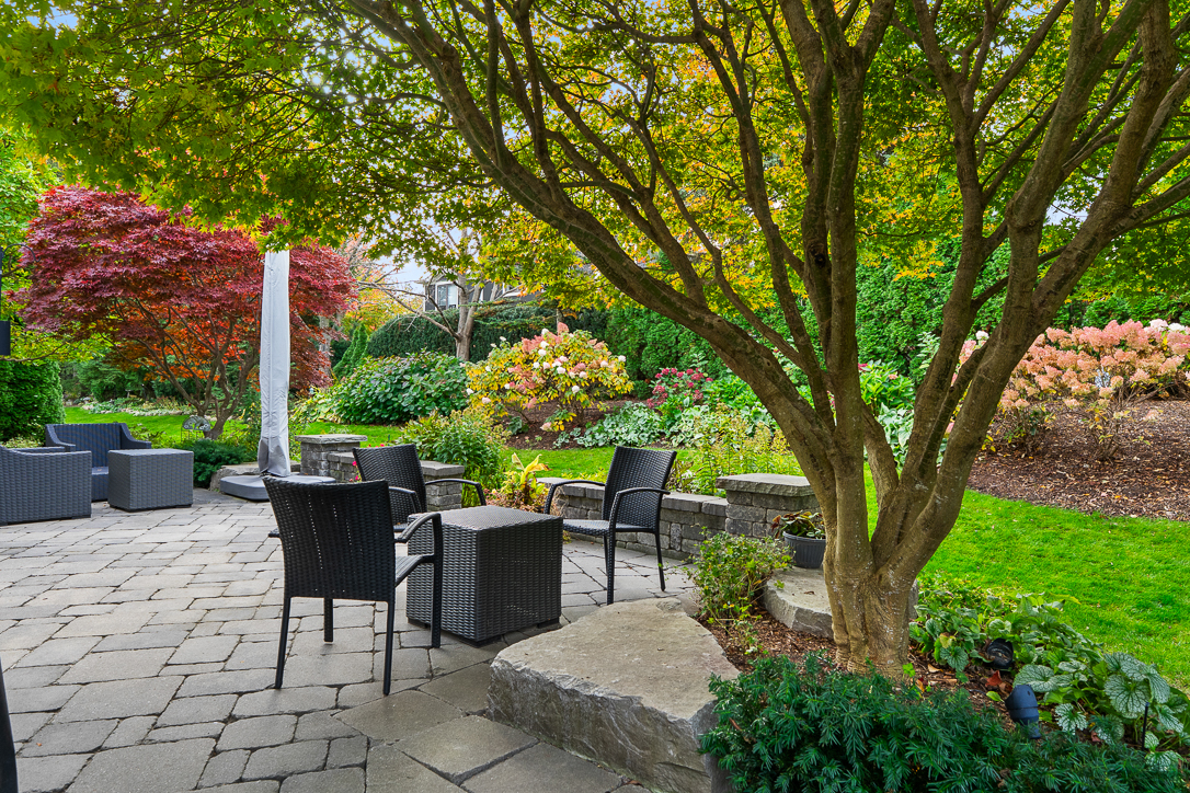 Cozy patio area with chairs, stone path, and lush garden plants