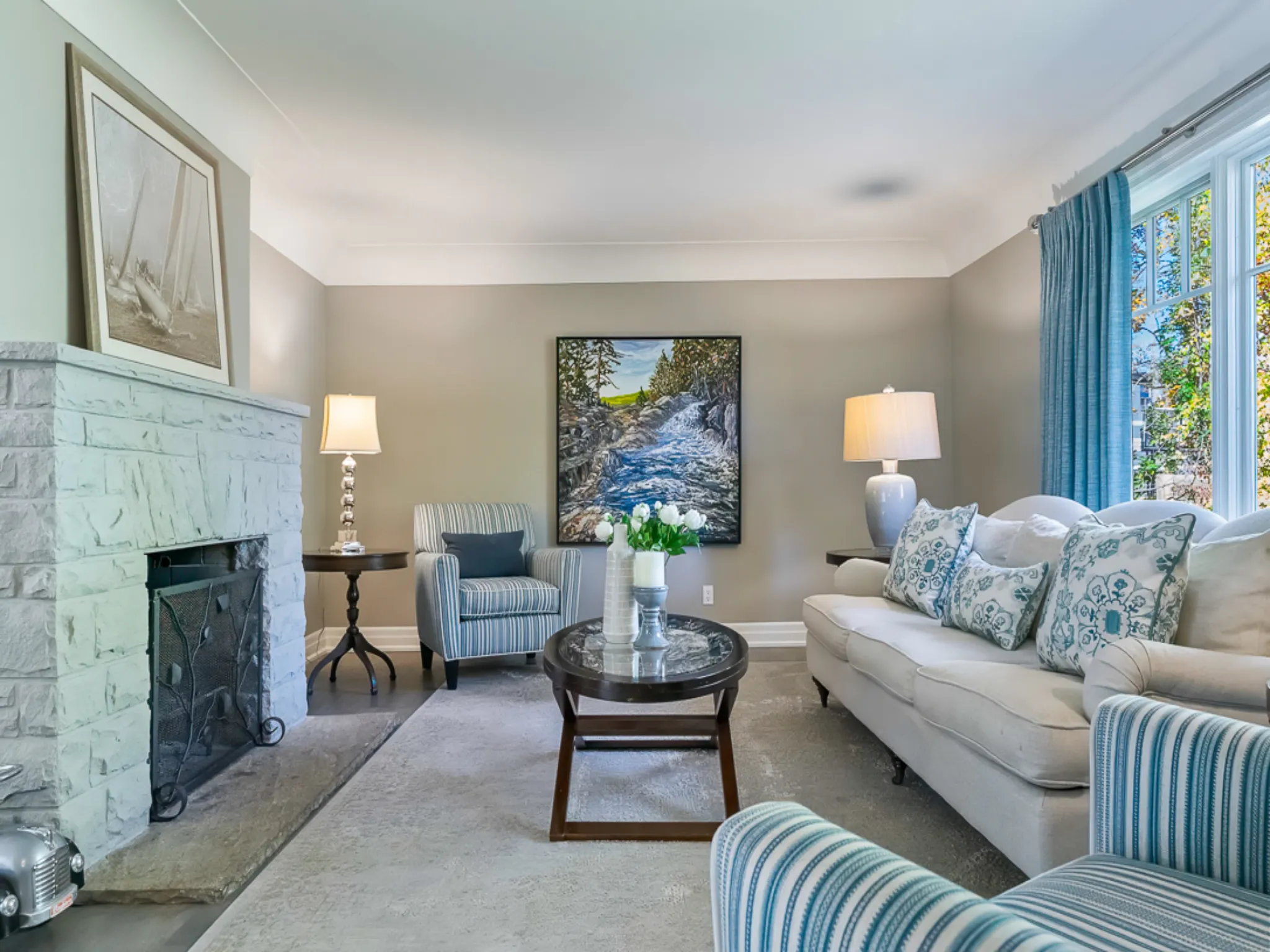 Cozy living room with a marble fireplace, blue accents, and artwork