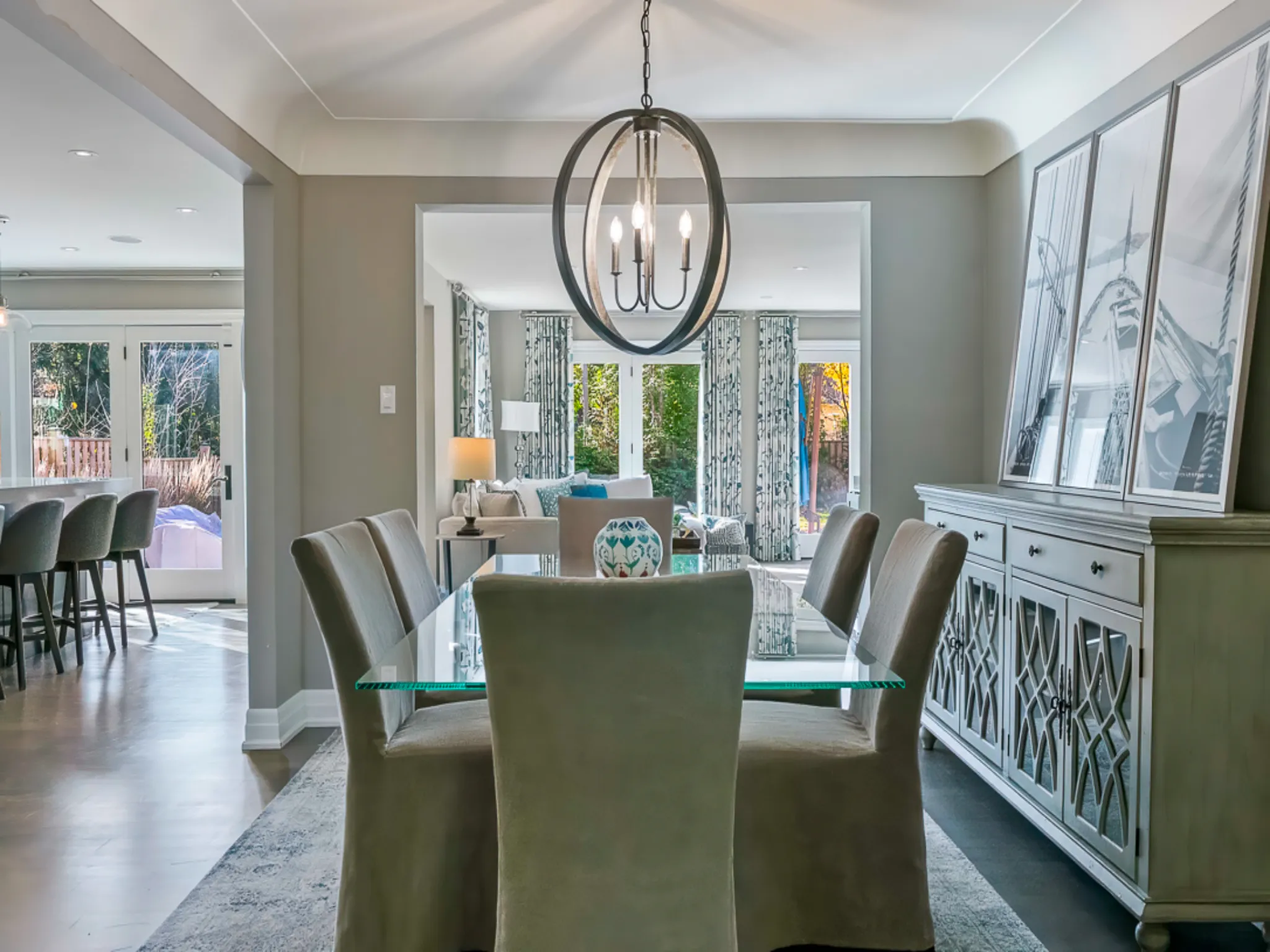 Modern dining room with a glass table, stylish chairs, and elegant lighting.