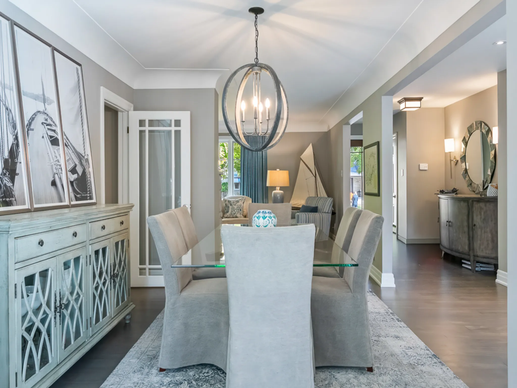 Modern dining room with a glass table, stylish chairs, and decorative lighting