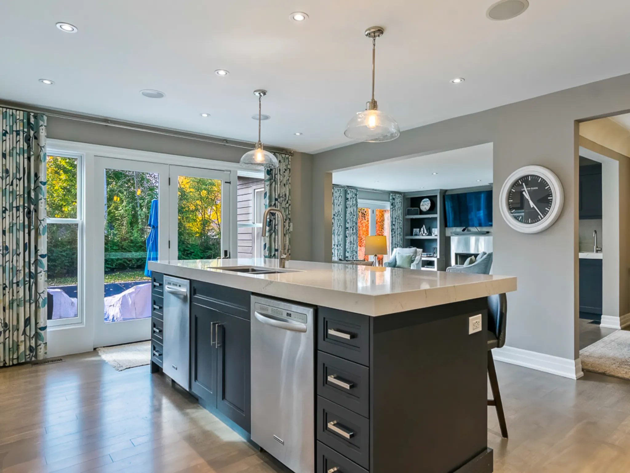 Modern kitchen with a large island, stainless steel appliances, and natural light.