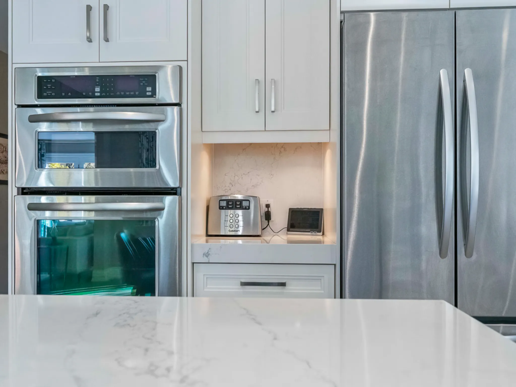 Modern kitchen featuring stainless steel appliances and marble countertop