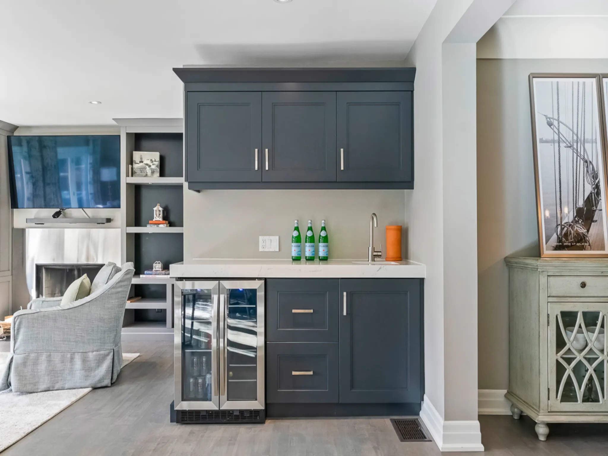 Modern kitchen with dark cabinetry, wine cooler, and decorative accents