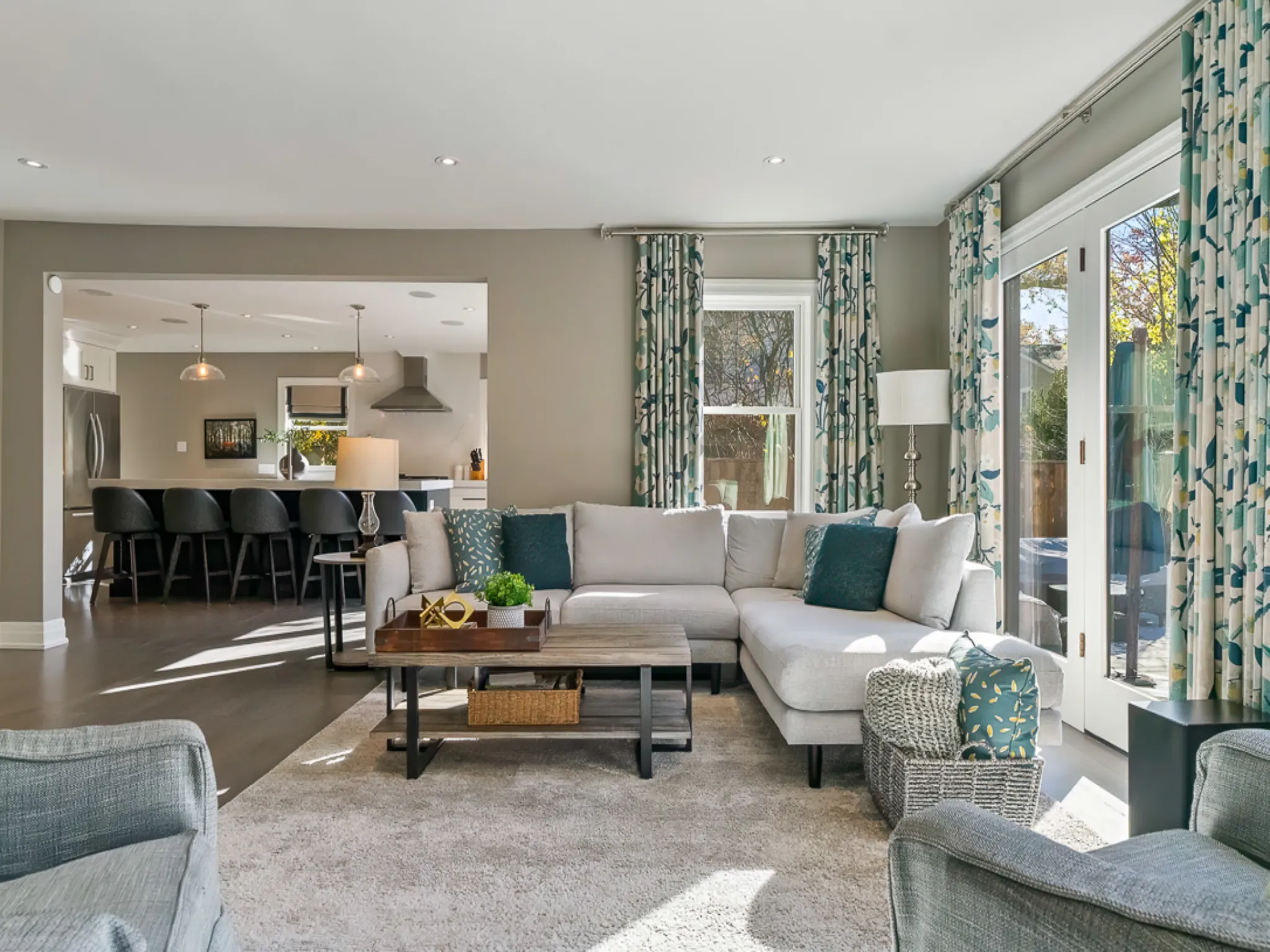 Modern living room with a light gray sectional sofa and colorful curtains