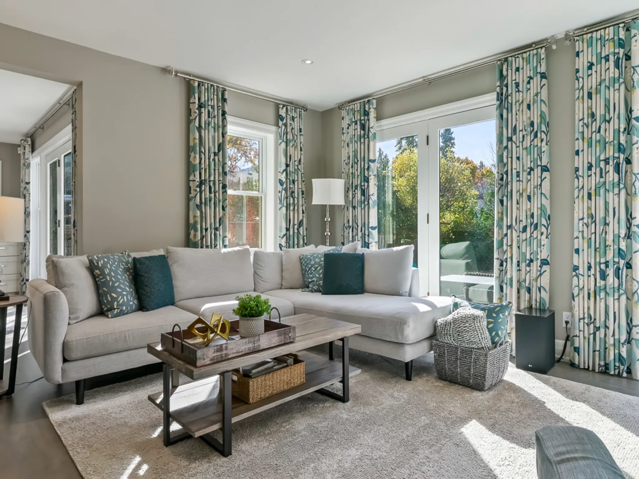 Bright living room with a gray sectional sofa and colorful curtains