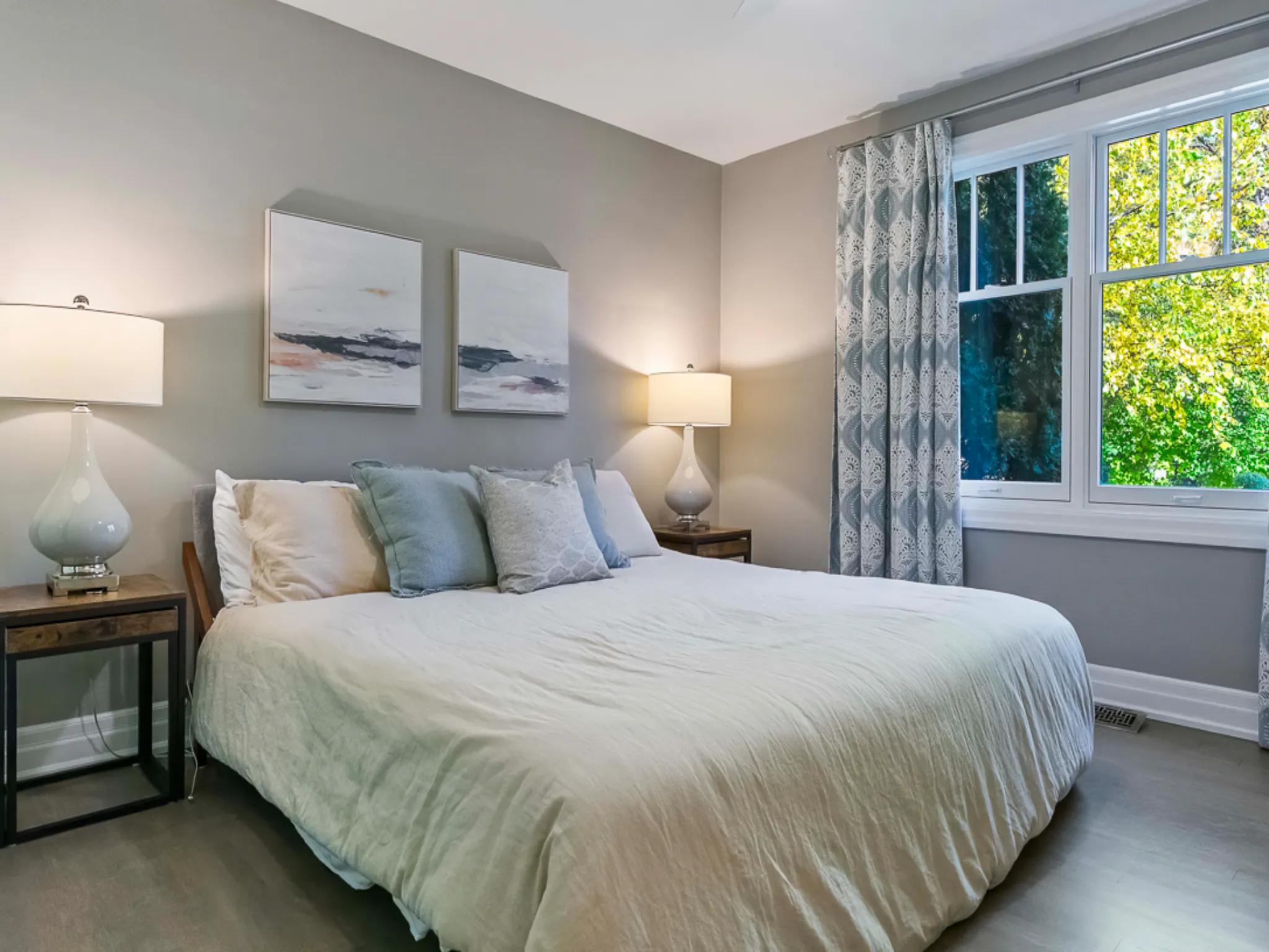 Cozy master bedroom with a large bed, artwork, and natural light