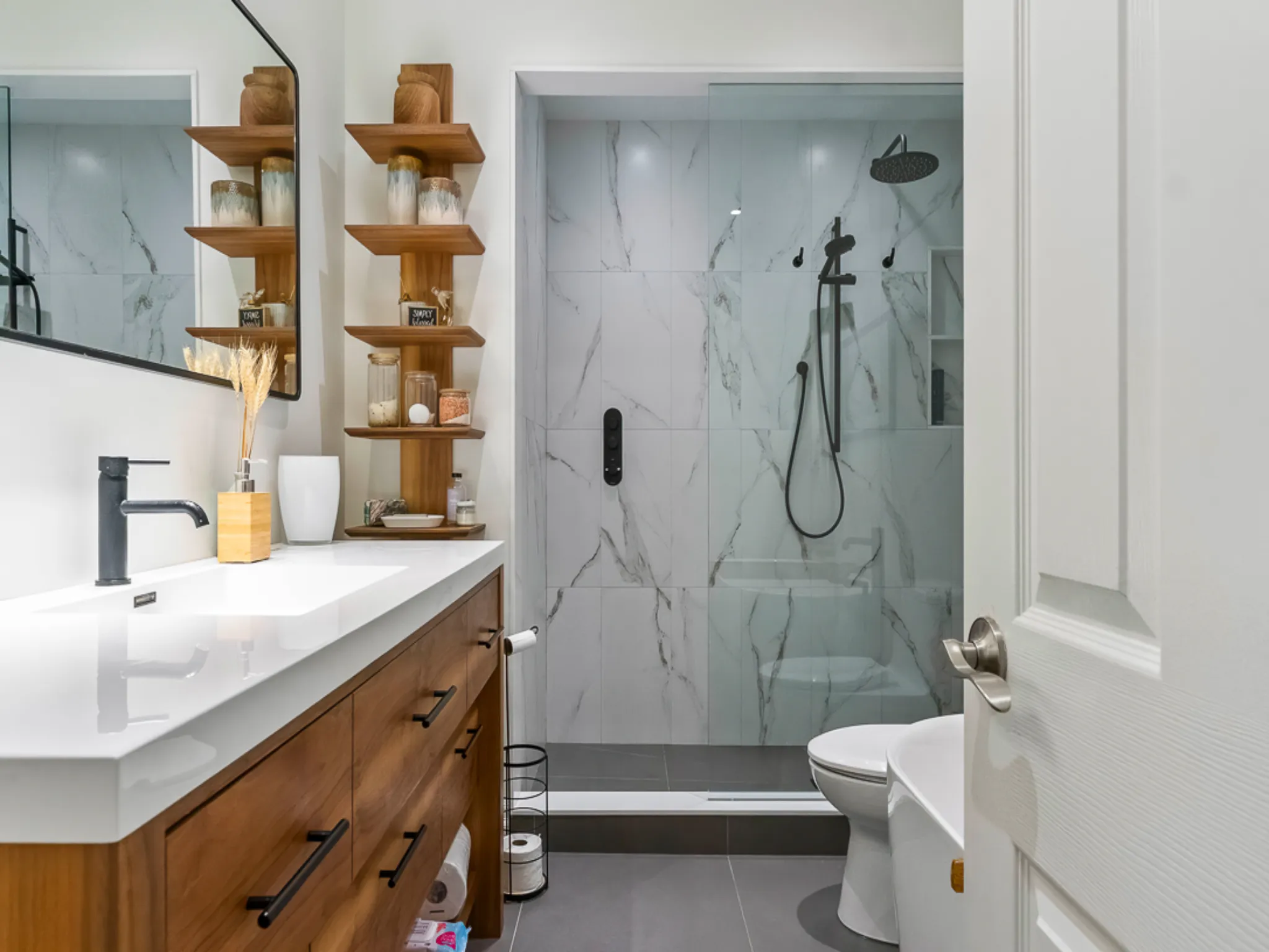 Modern master bathroom with wooden vanity and glass shower enclosure