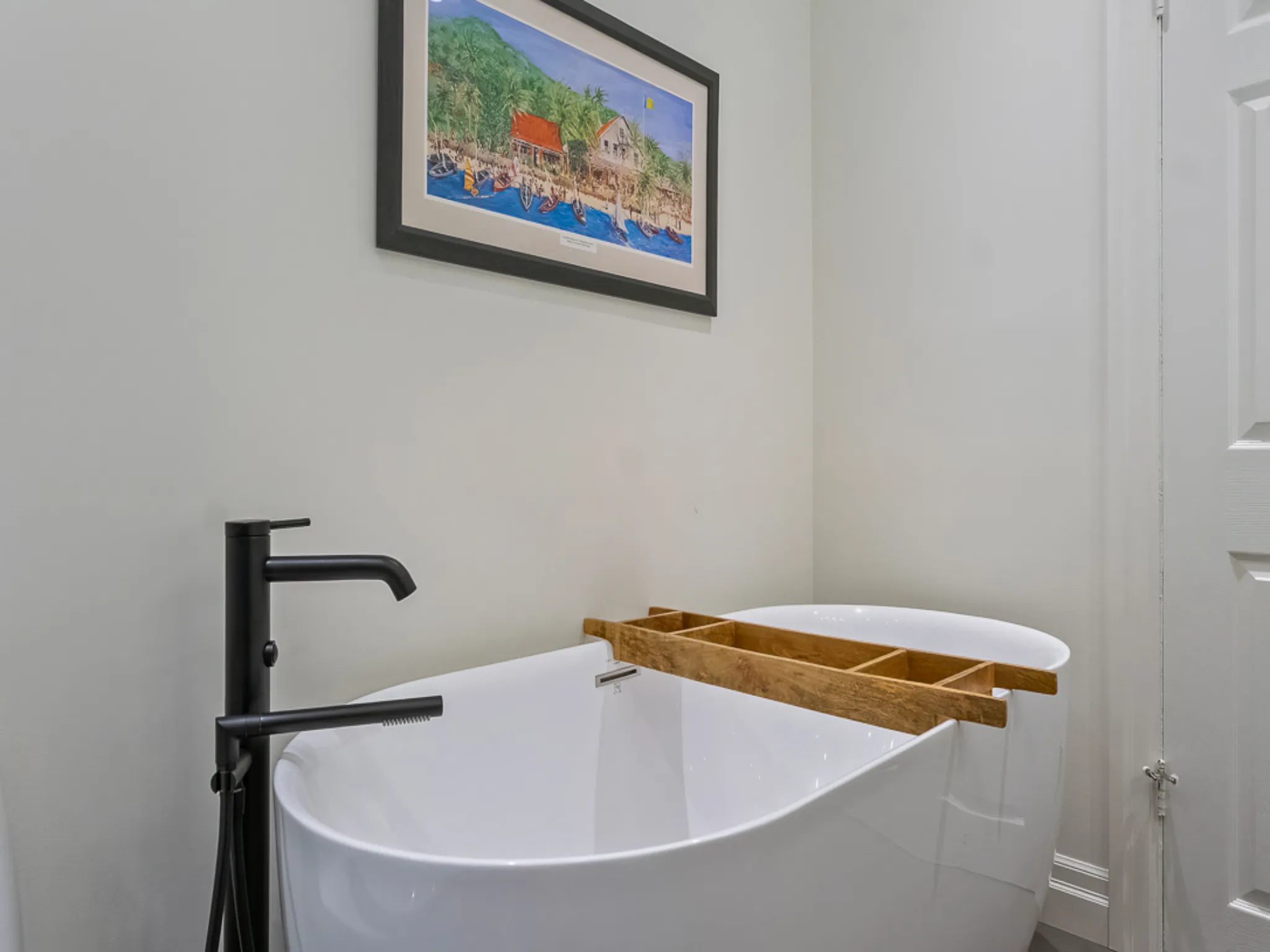 Modern master bathroom featuring a freestanding tub and framed artwork