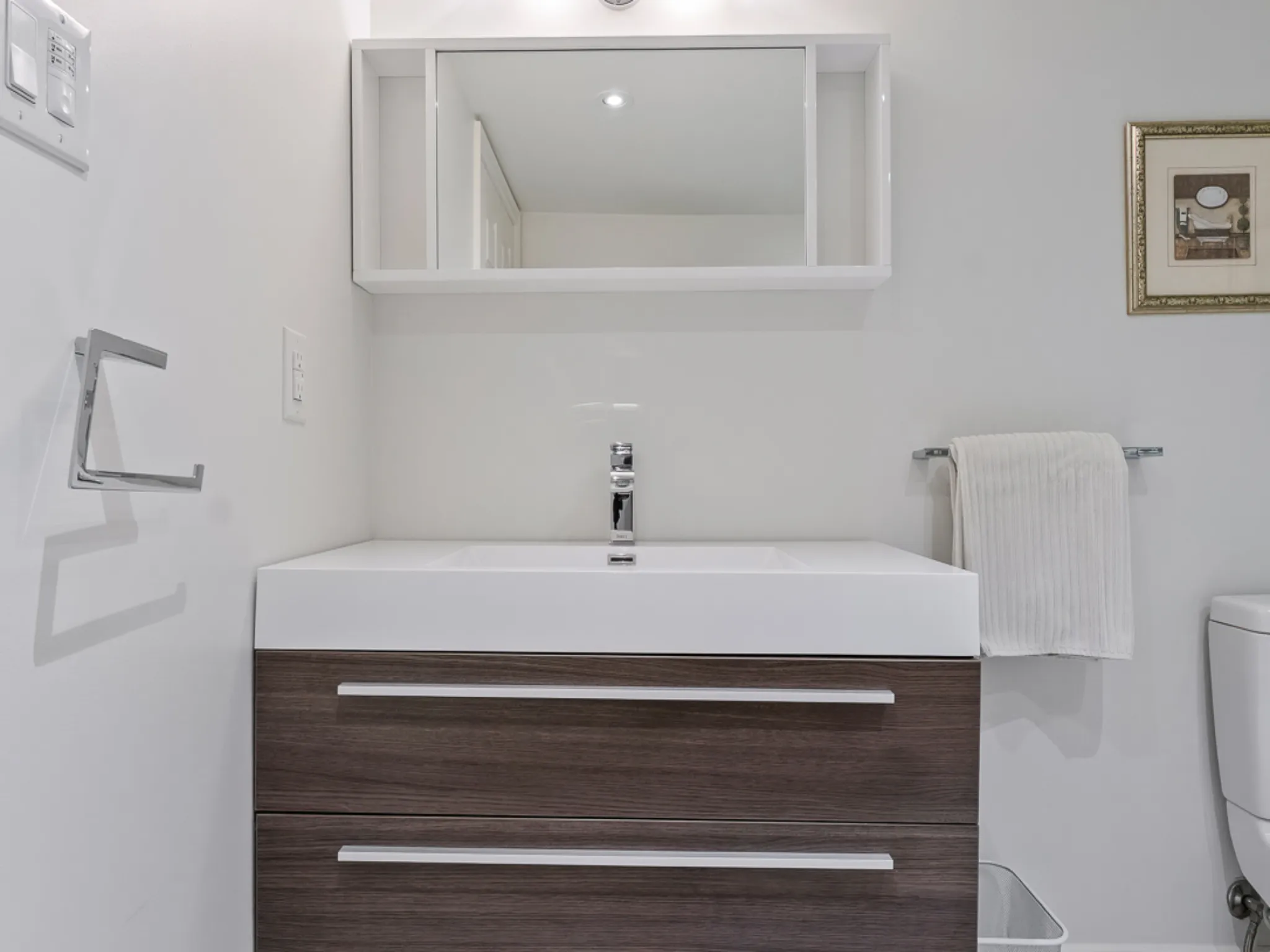 Modern bathroom featuring a sleek vanity, mirror, and towel rack