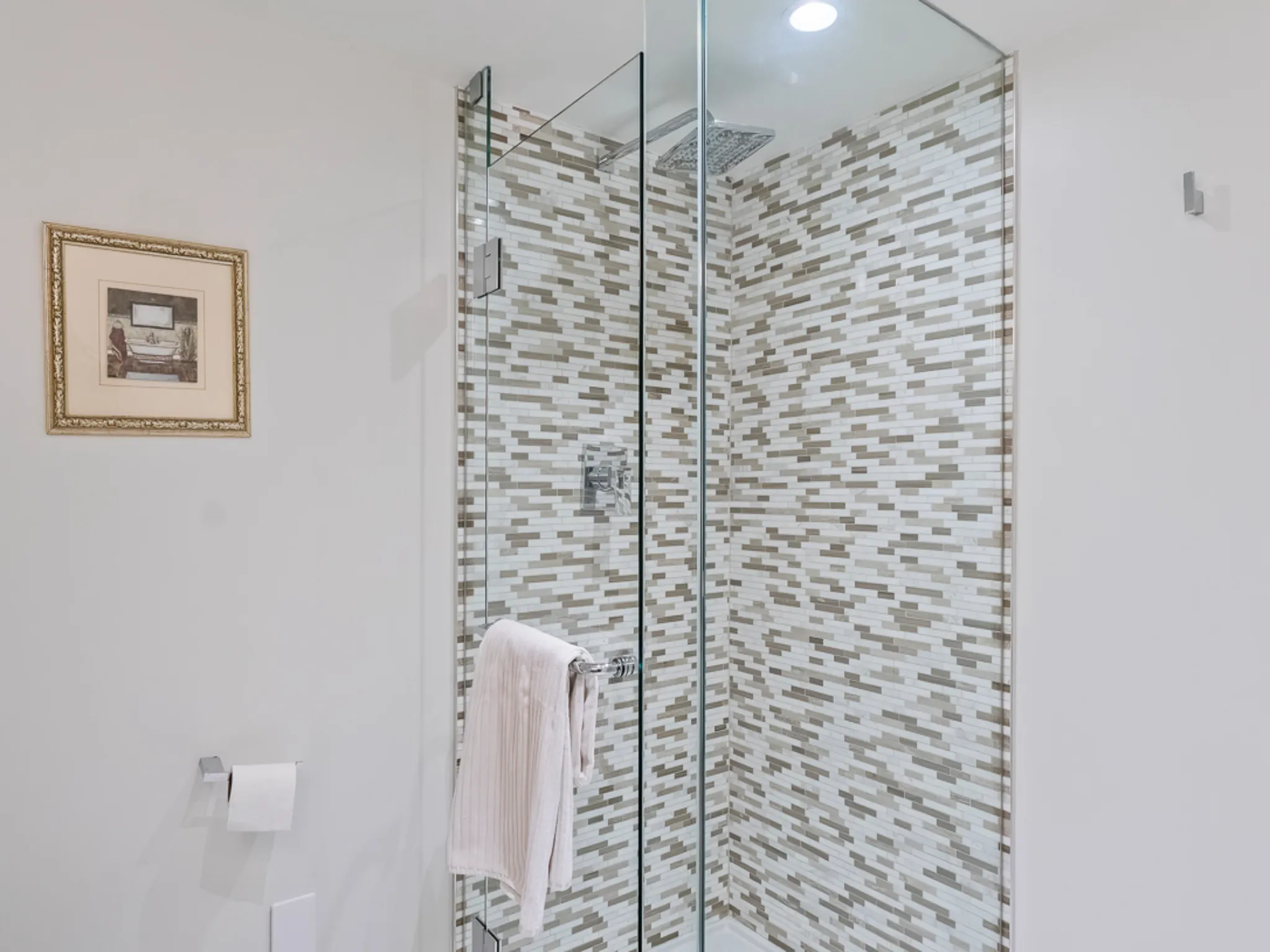 Modern bathroom featuring a glass shower and patterned tile wall