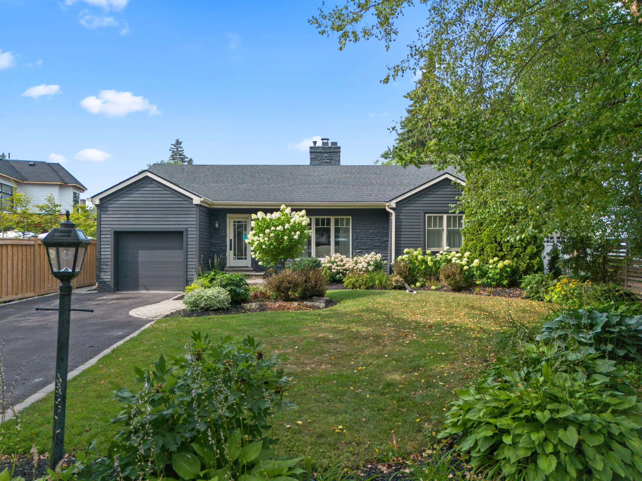 Single-story gray house with landscaped front yard and driveway
