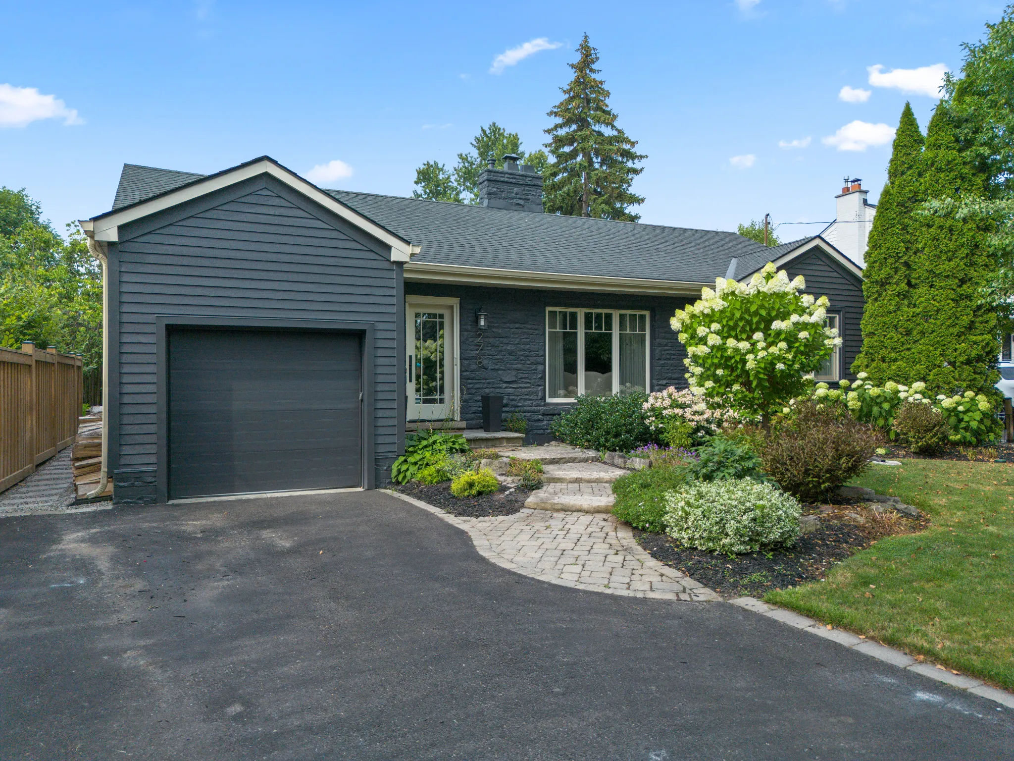 Modern gray house with landscaped garden and driveway