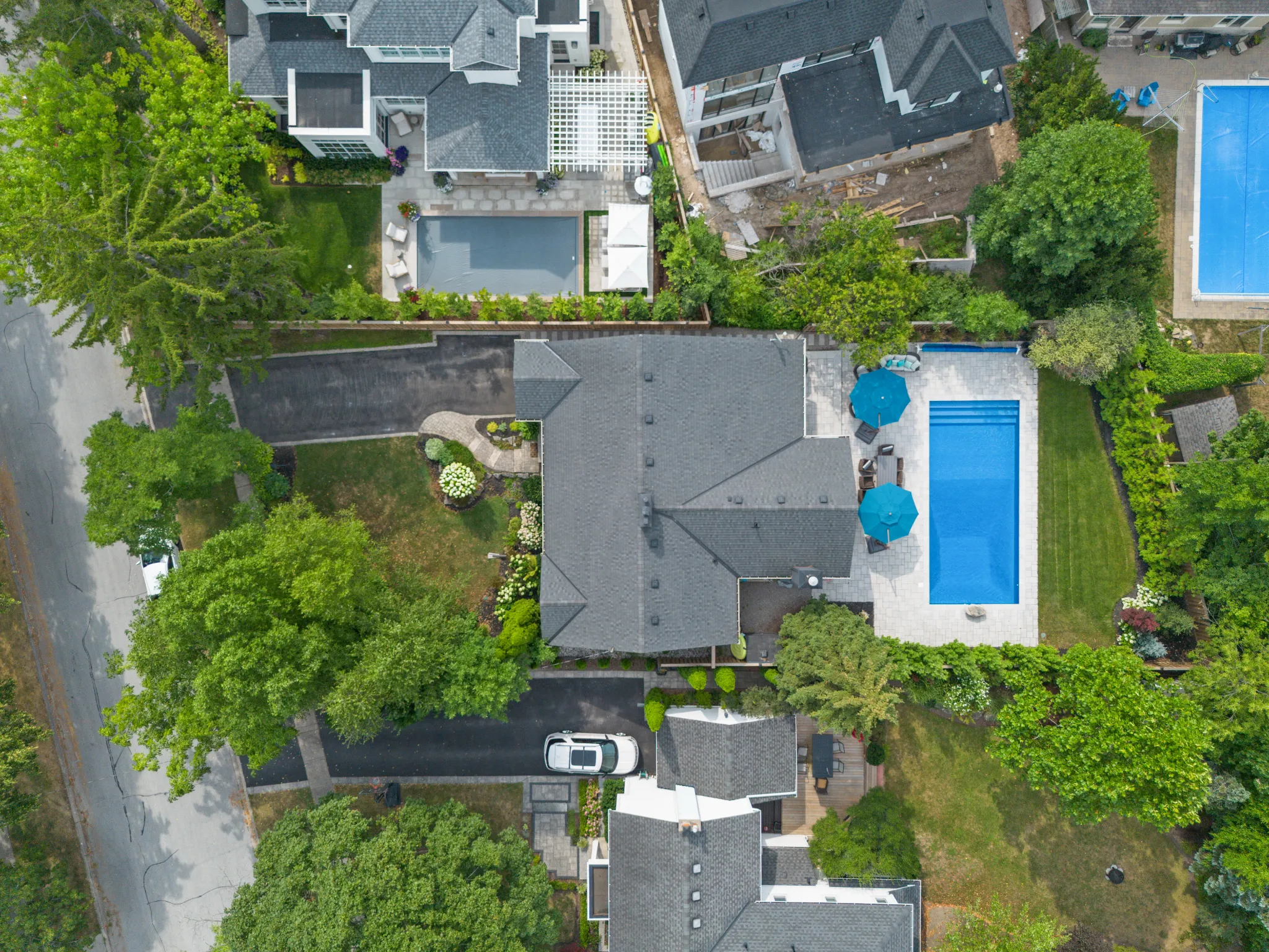 Aerial view of a house with a pool and surrounding greenery