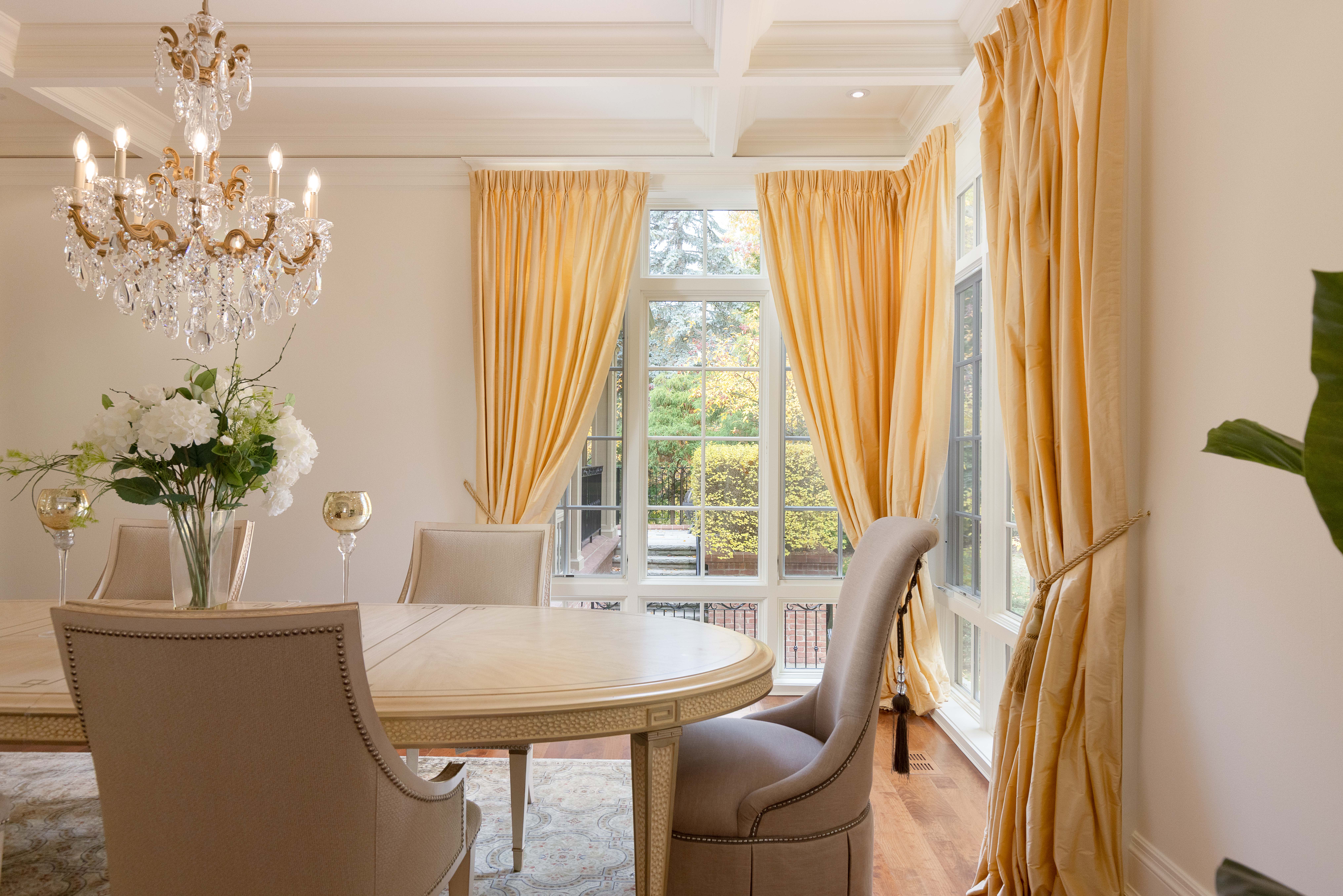 Elegant dining room with a chandelier and yellow curtains