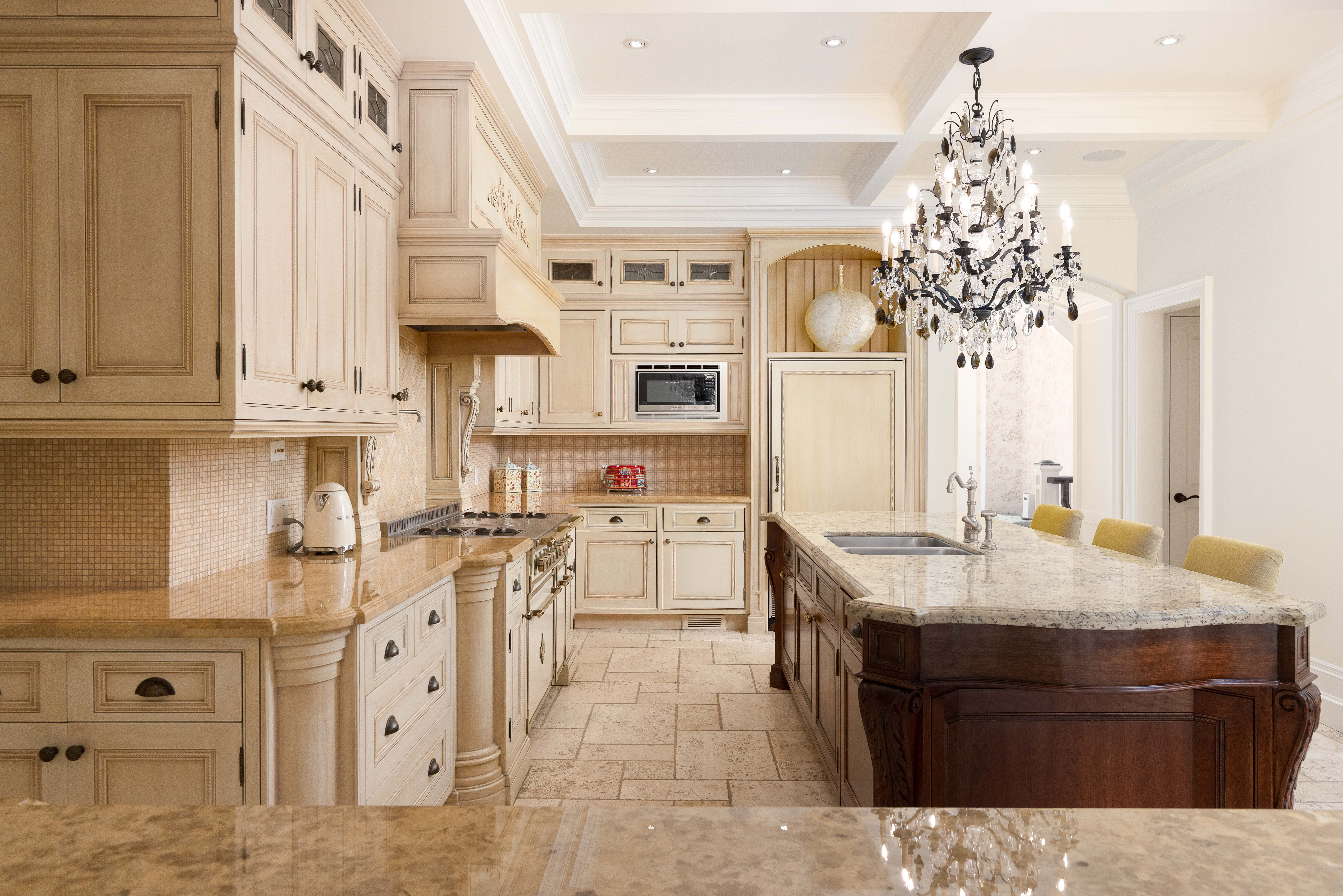 Elegant kitchen with cream cabinets, granite island, and a chandelier
