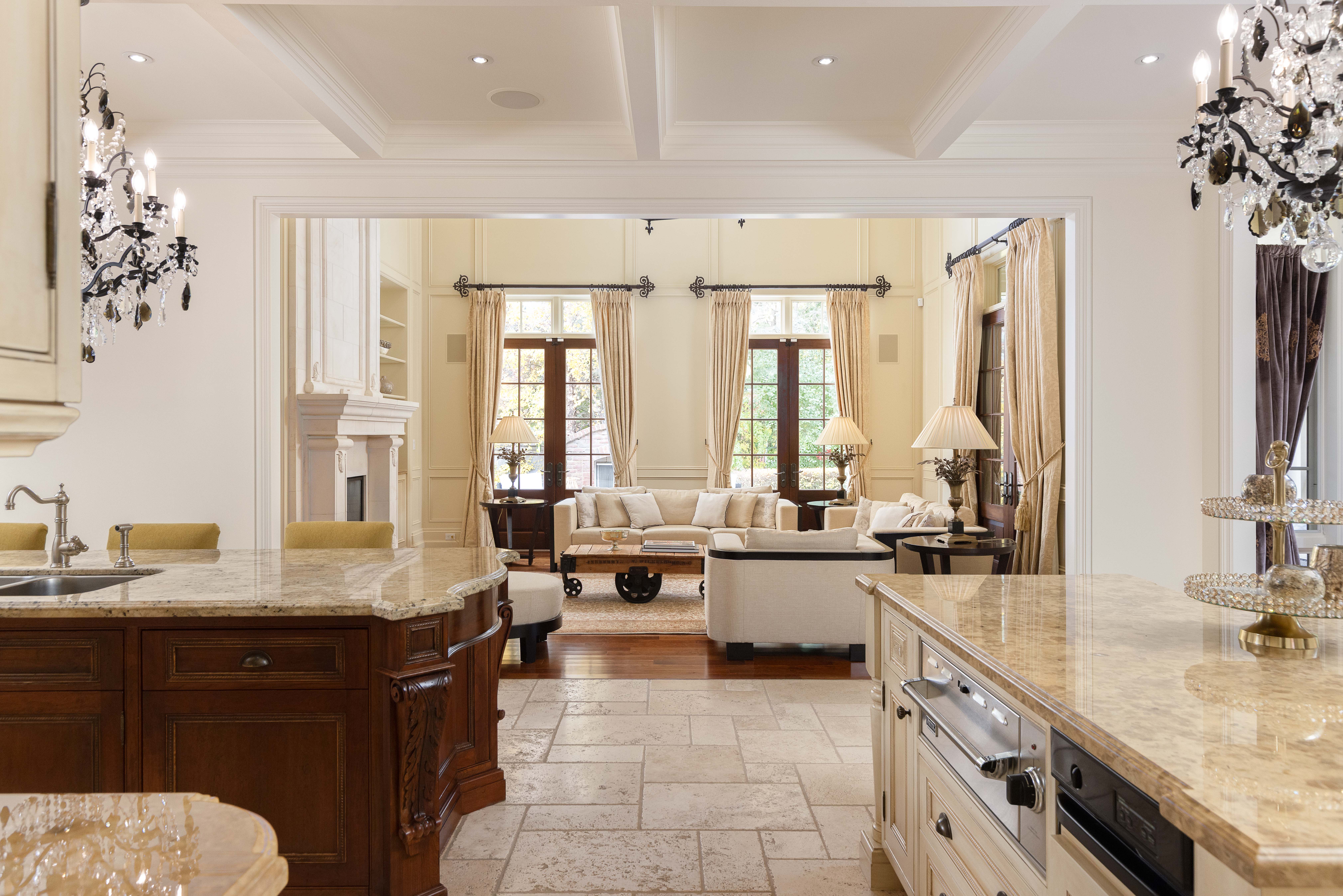 Elegant kitchen with marble countertops and a view of a cozy living room