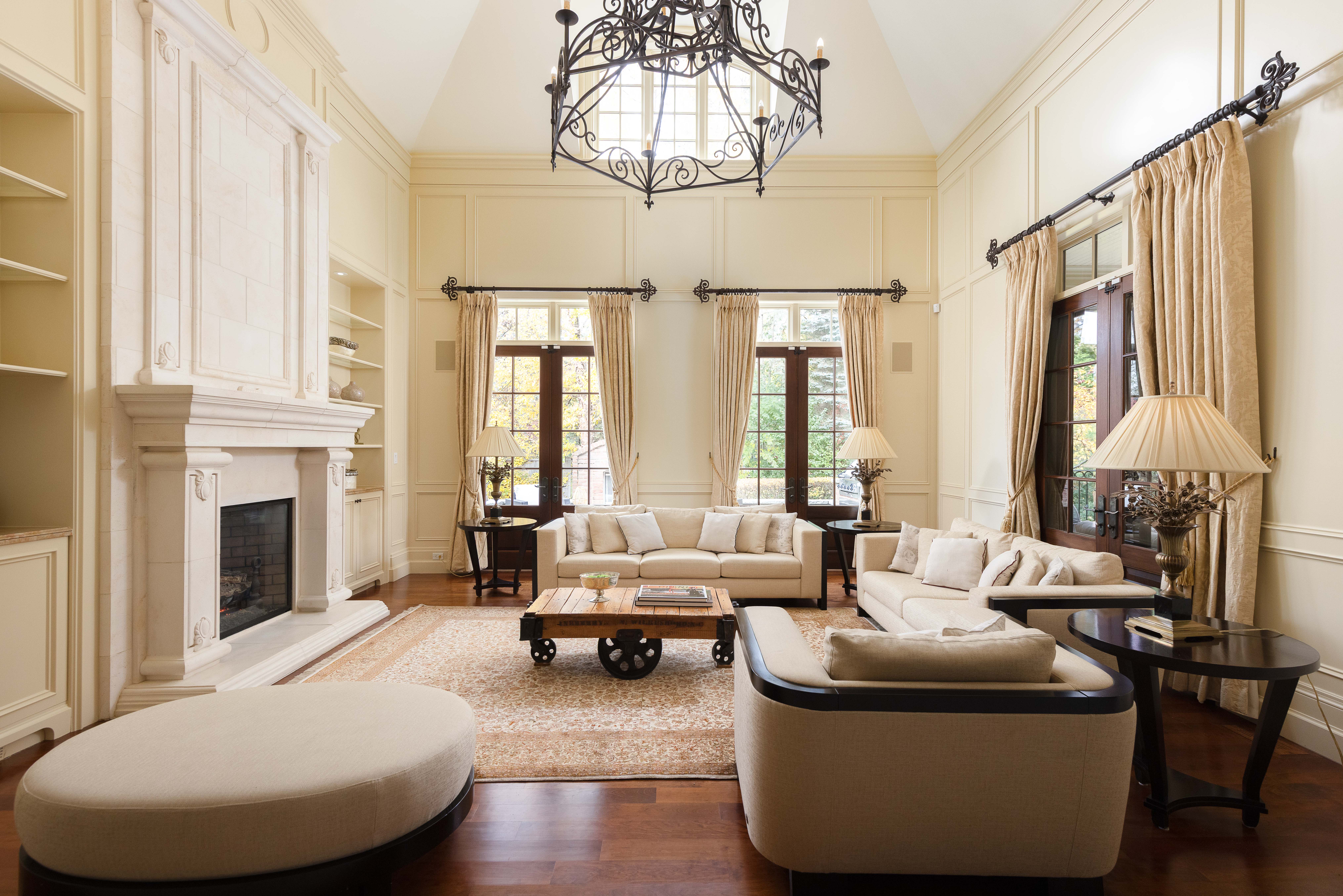 Elegant living room with a chandelier, beige furniture, and large windows