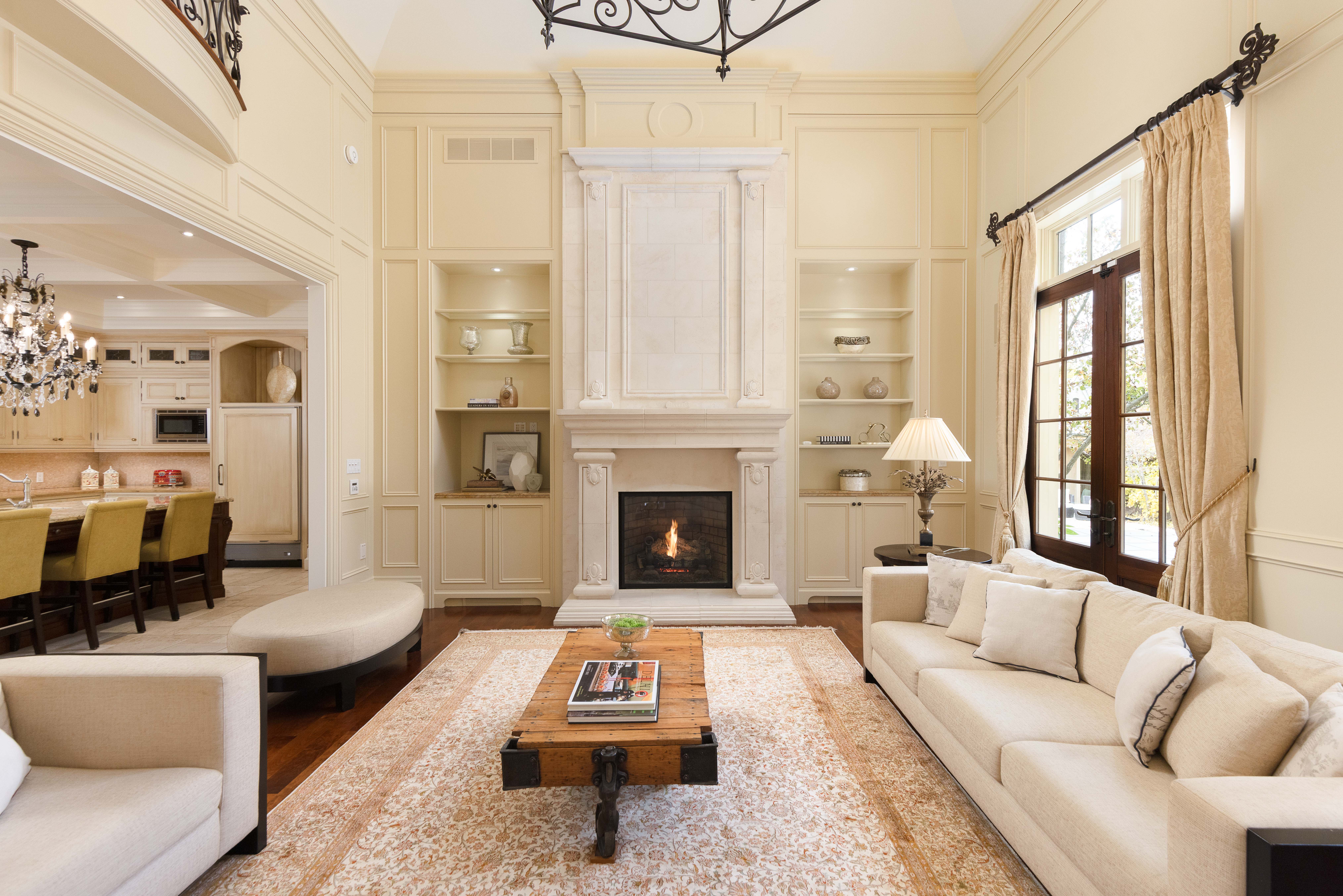 Elegant living room with cream sofas, a fireplace, and a wooden coffee table