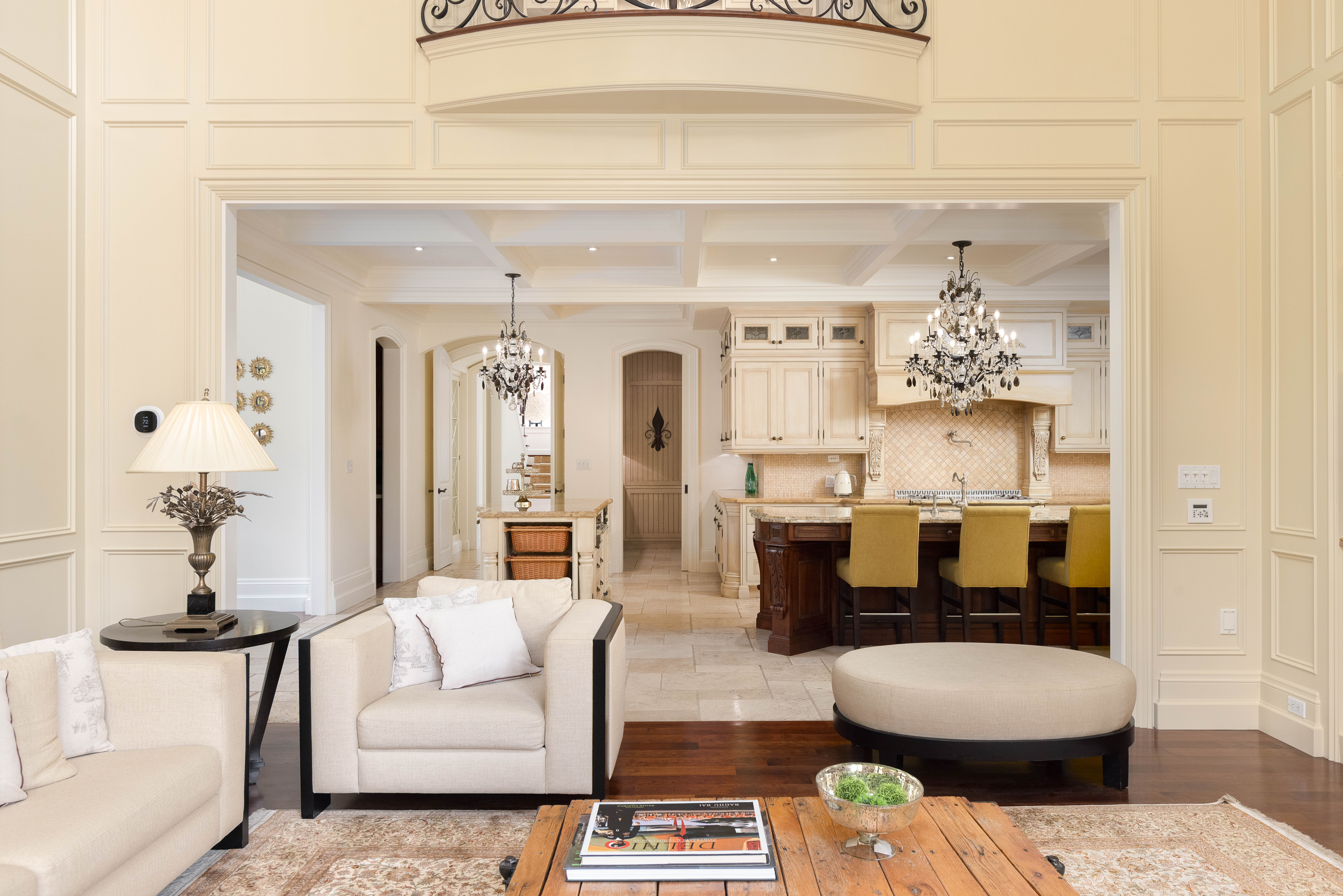 Elegant living room with cream sofas and a view of the kitchen