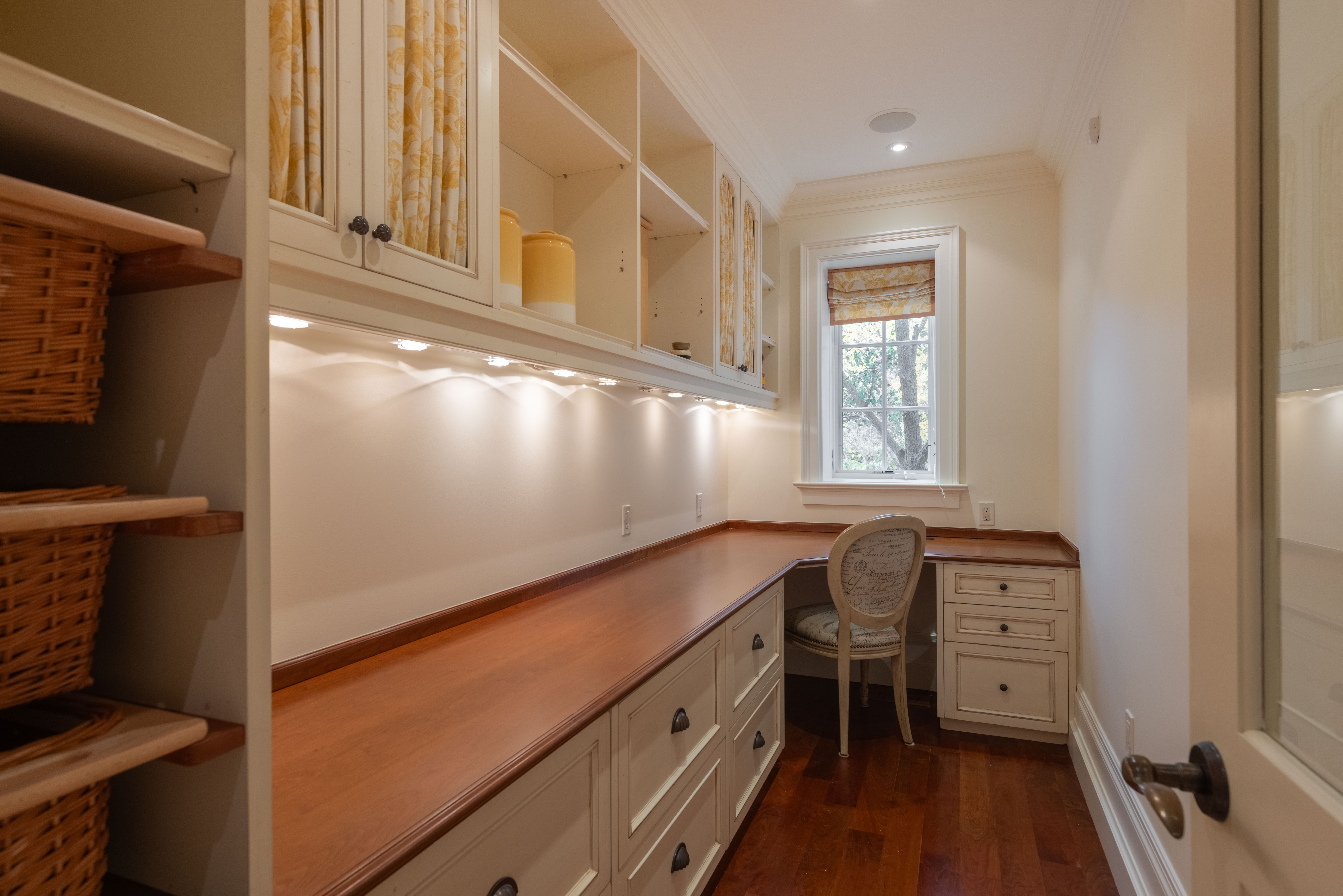 Bright home office with wooden desk and shelving units