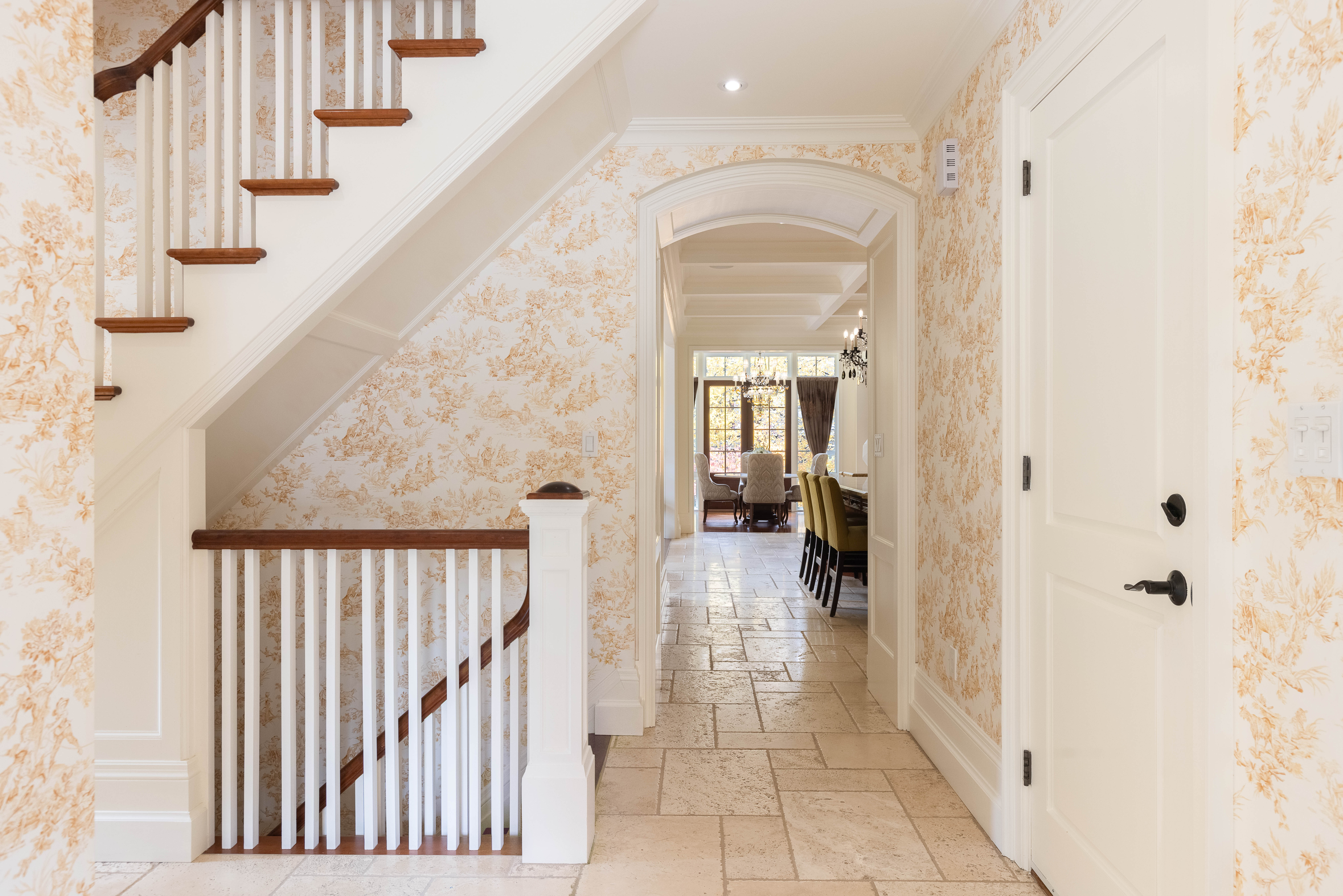 Elegant hallway with floral wallpaper and wooden staircase