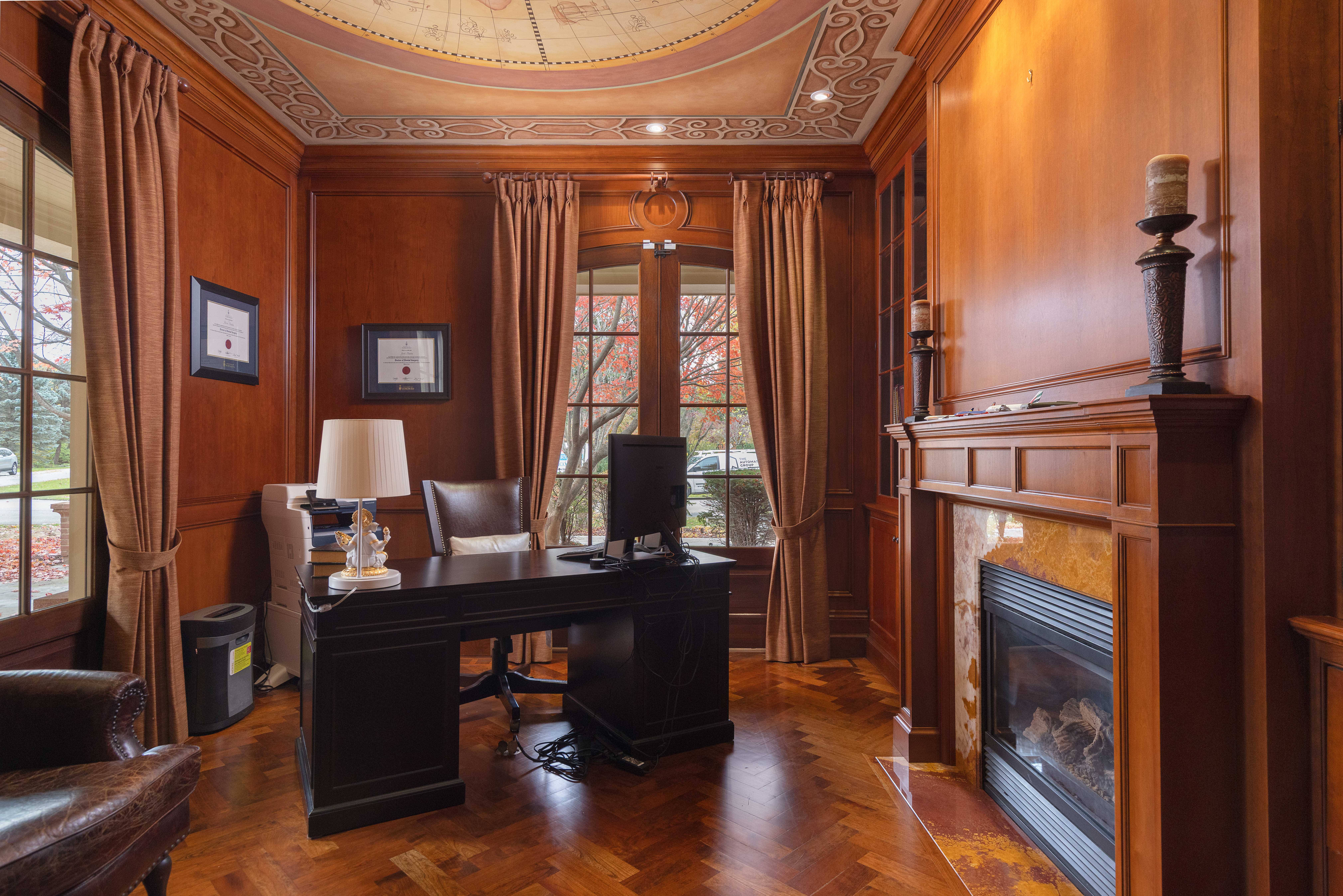 Elegant wooden office with a fireplace and large windows
