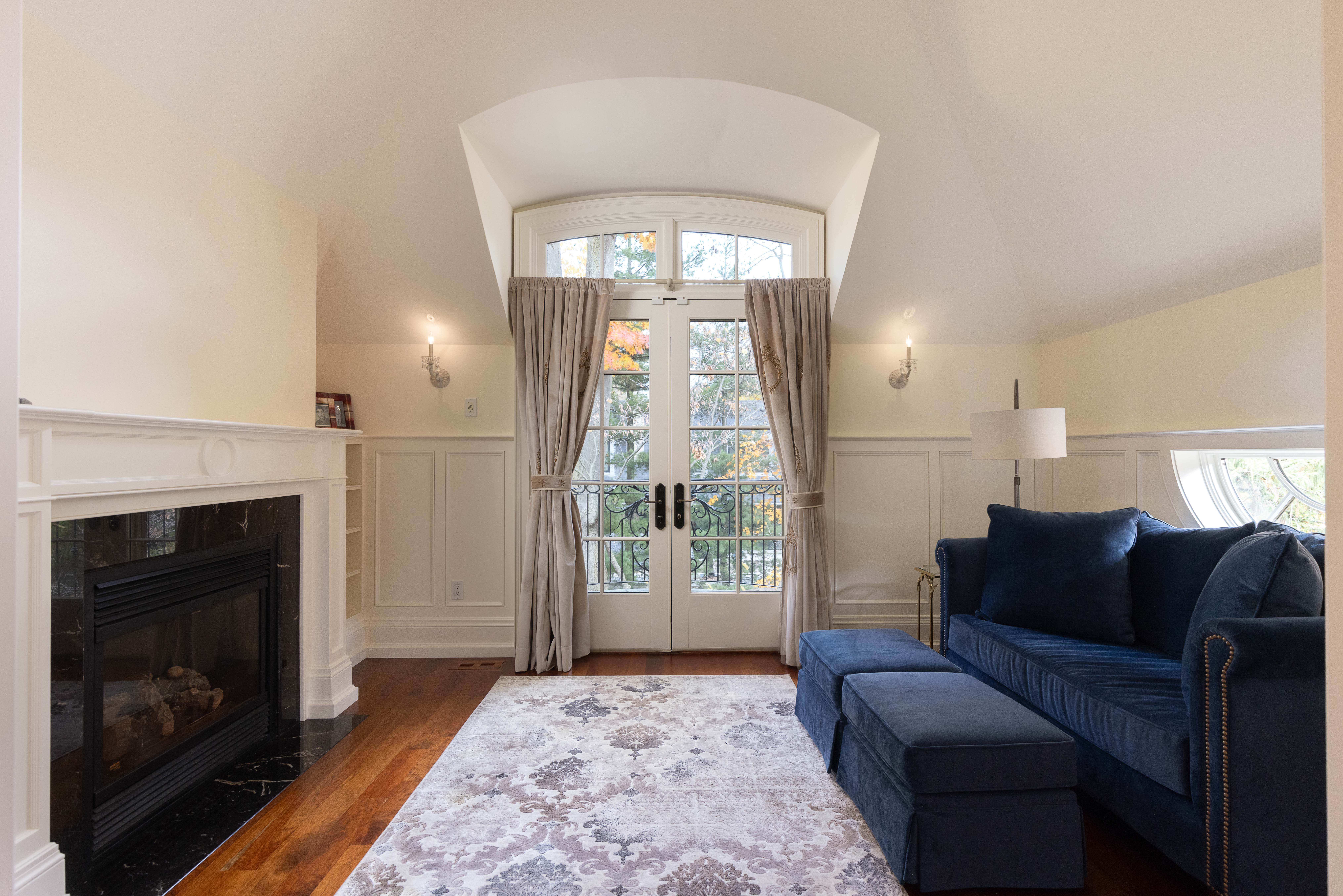 Cozy living room with a blue sofa, fireplace, and large windows