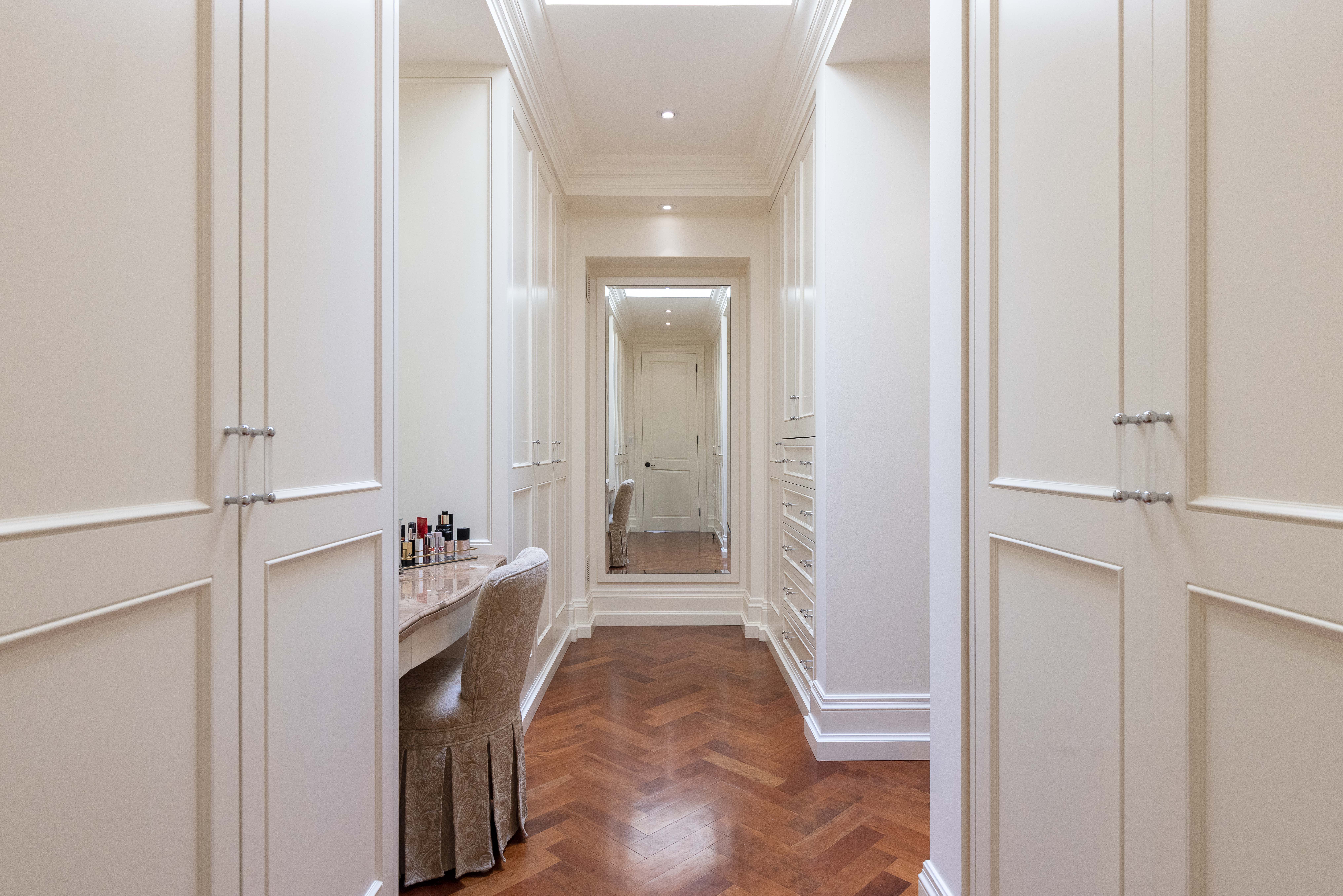 Elegant hallway with mirrored vanity and wooden herringbone flooring