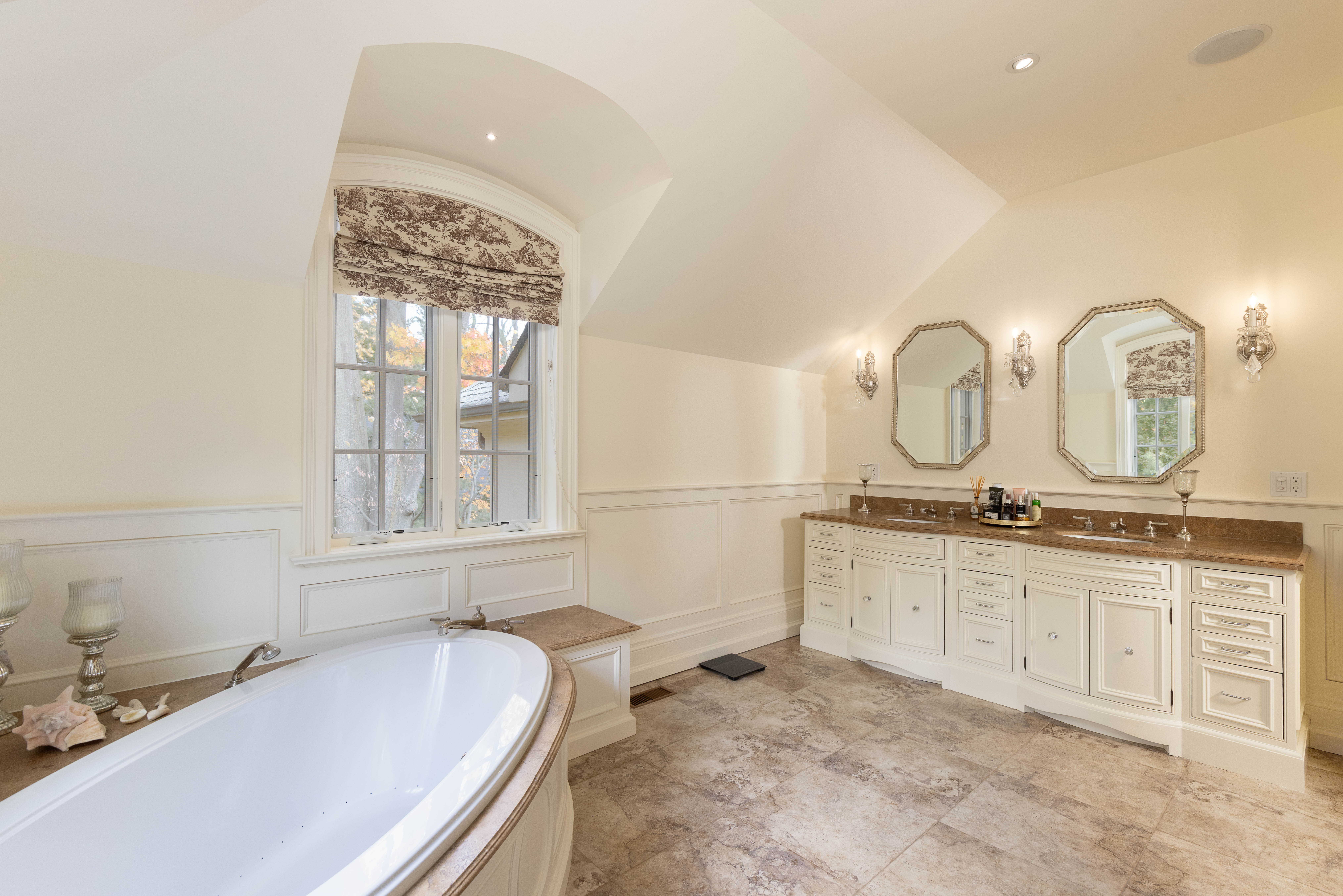 Elegant bathroom featuring a freestanding tub, double sinks, and large windows