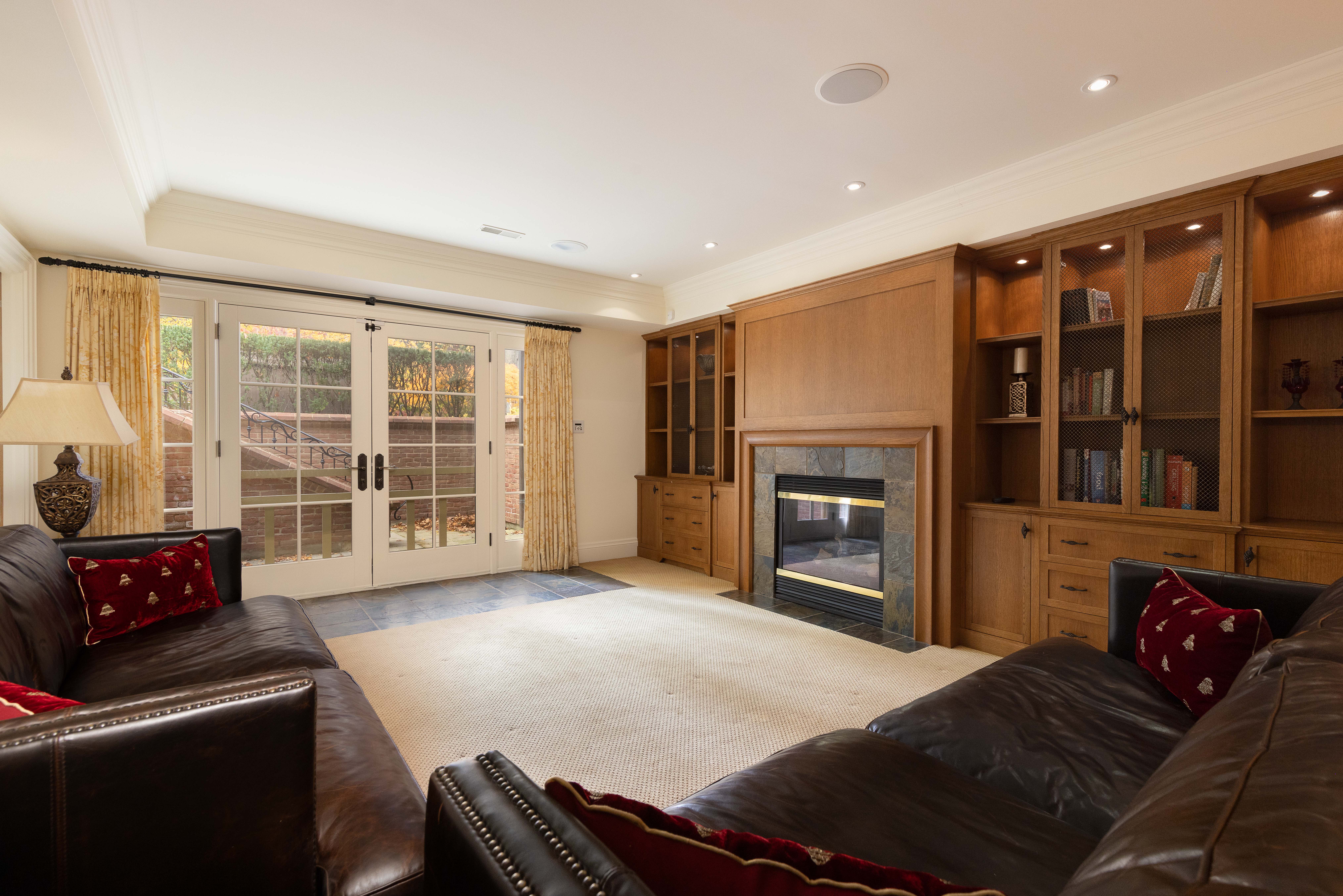 Cozy living room with leather sofas, fireplace, and built-in shelves