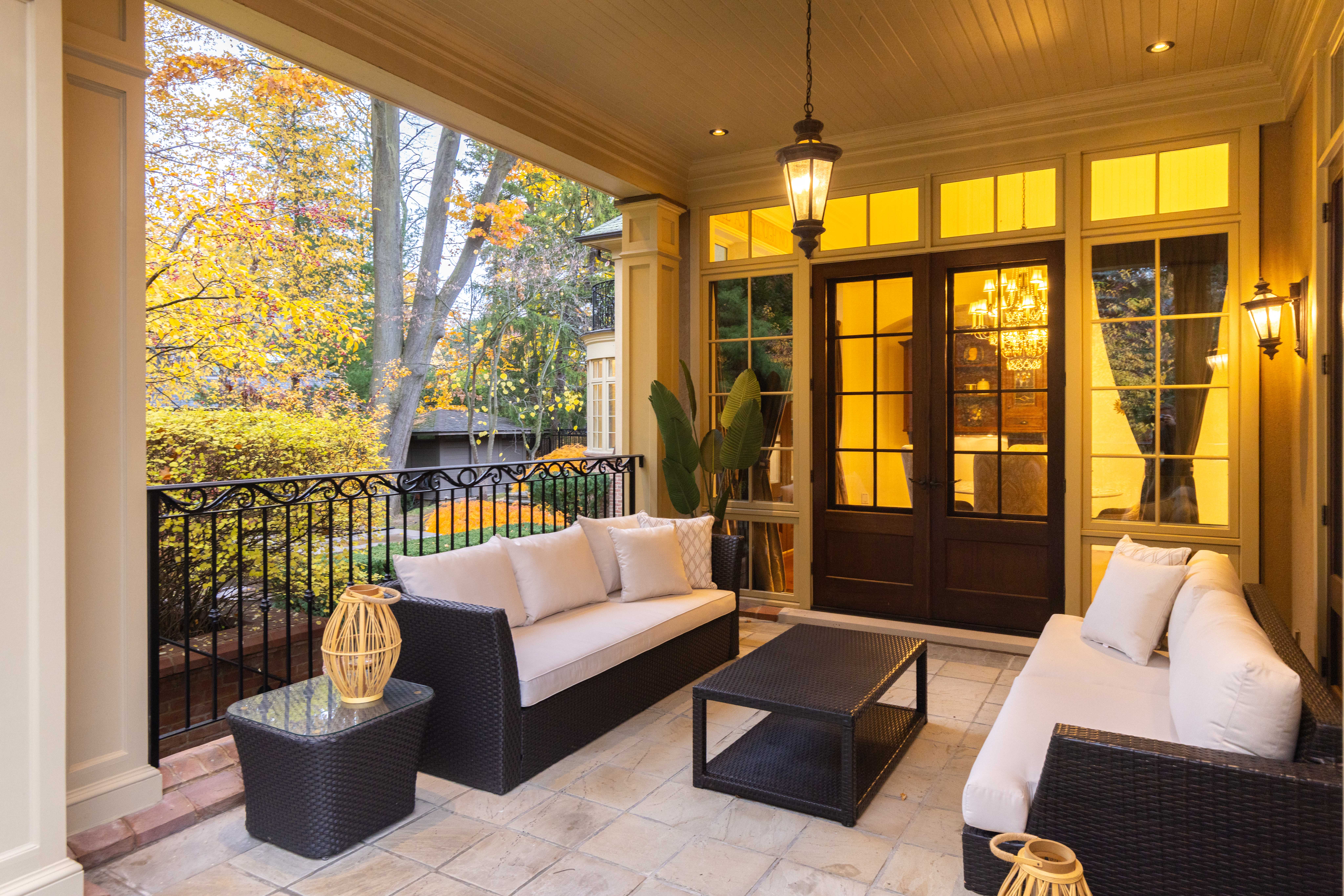 Cozy porch with seating, coffee table, and warm lighting at sunset