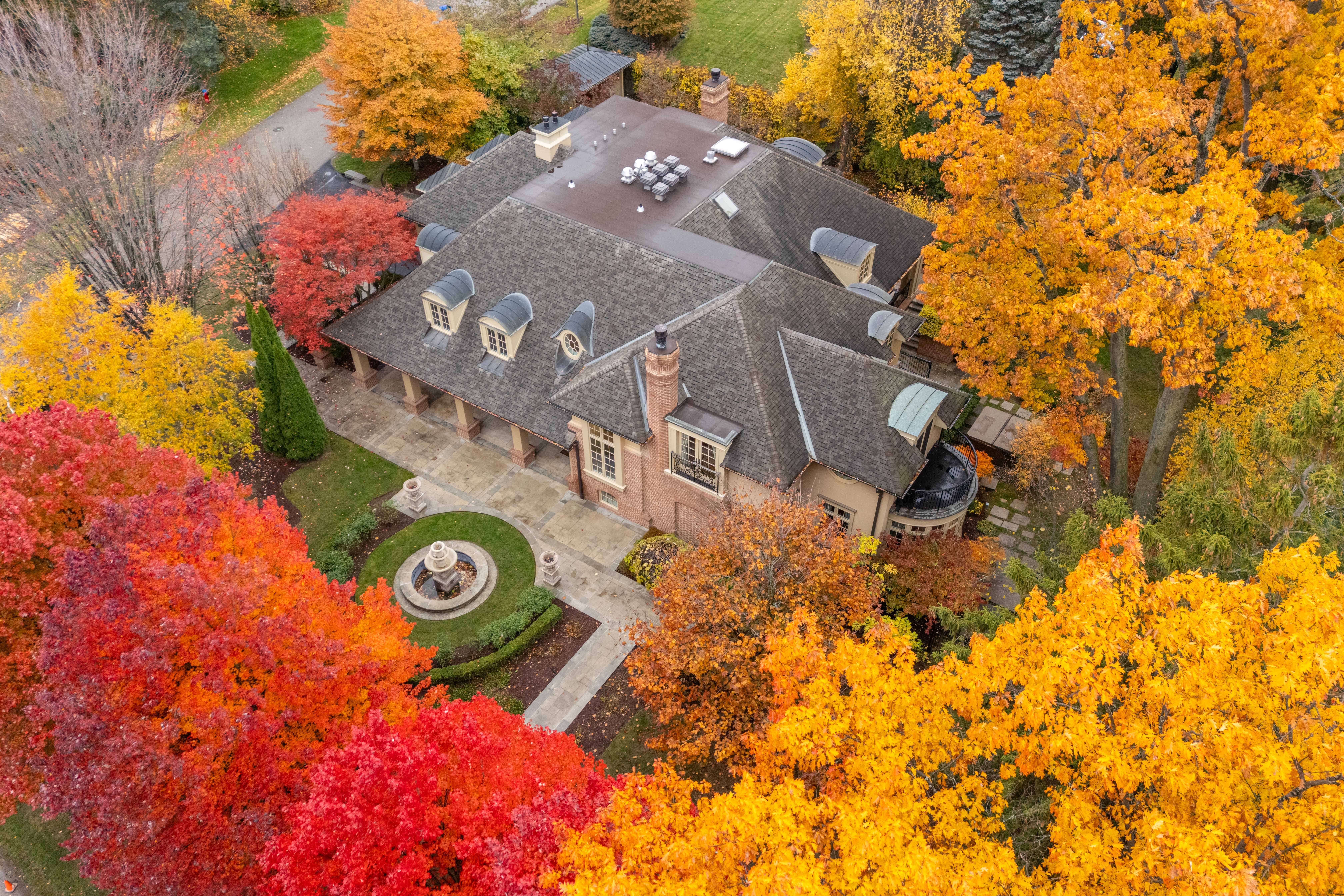 Aerial view of a house surrounded by vibrant autumn foliage