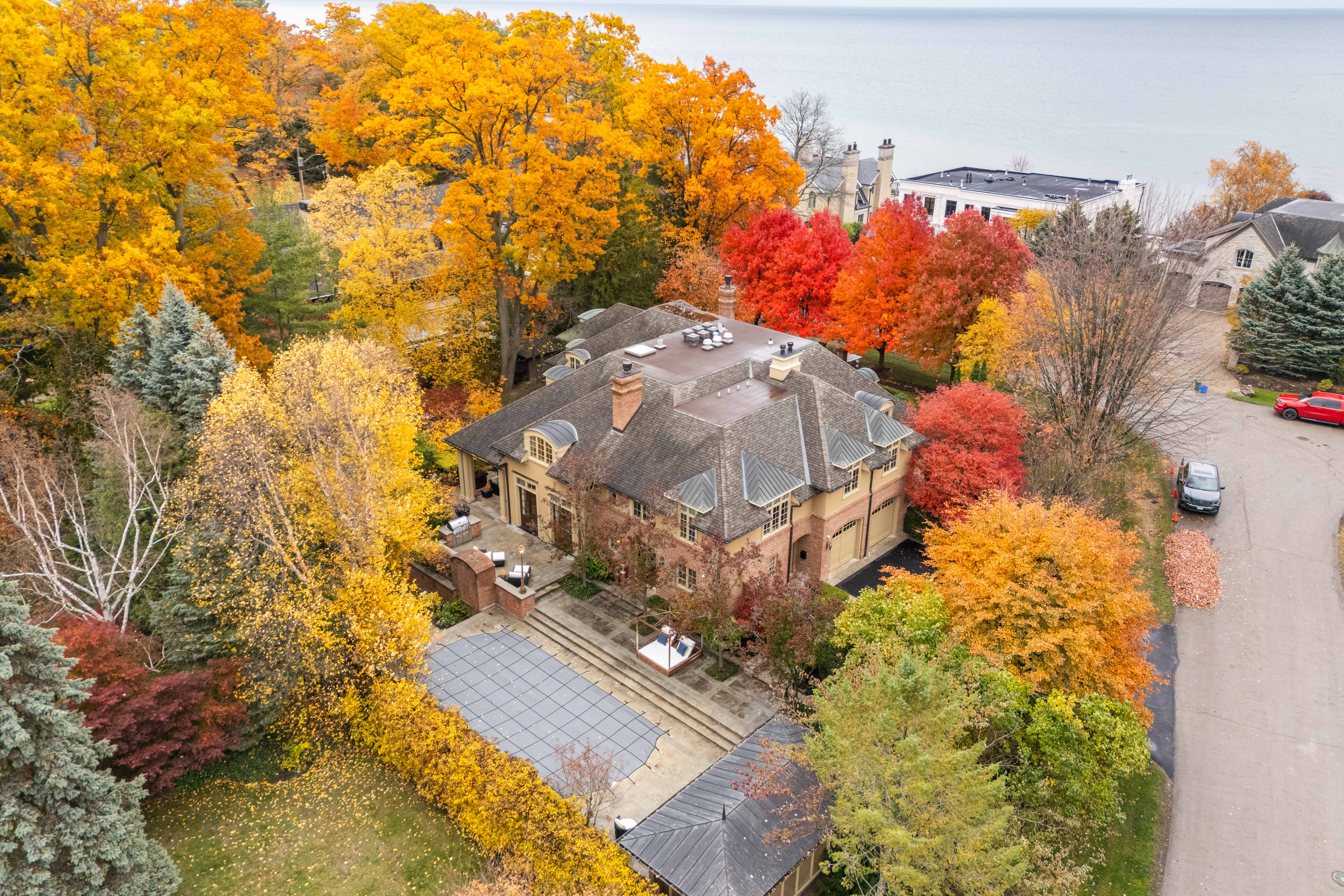Aerial view of a large house surrounded by vibrant autumn foliage