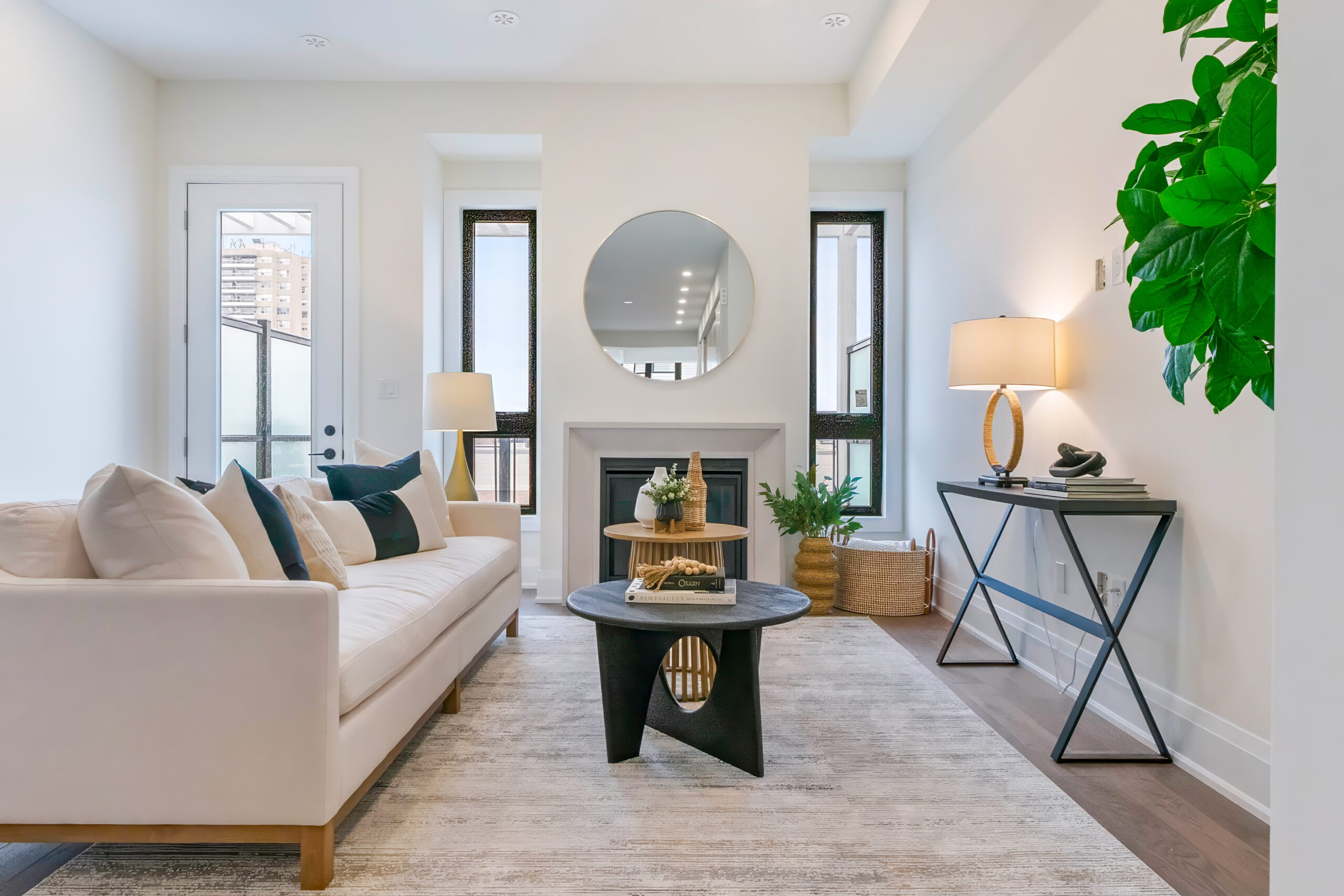 Modern living room with a beige sofa, round mirror, and stylish decor