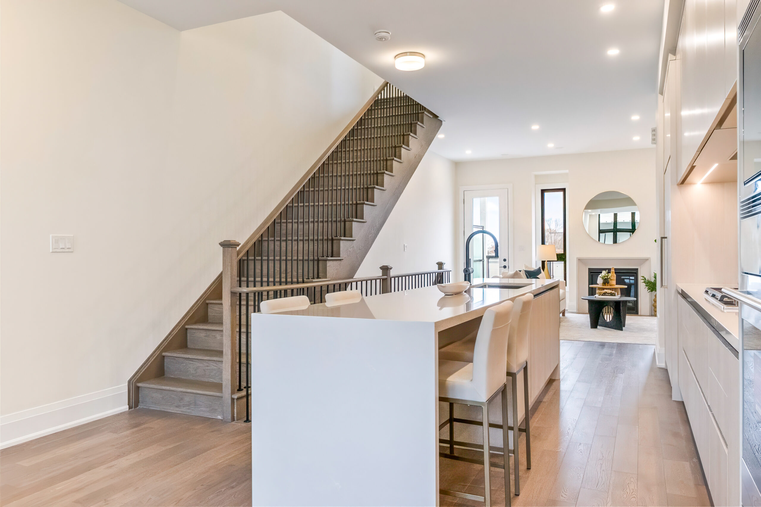 Modern kitchen with island, staircase, and cozy living area