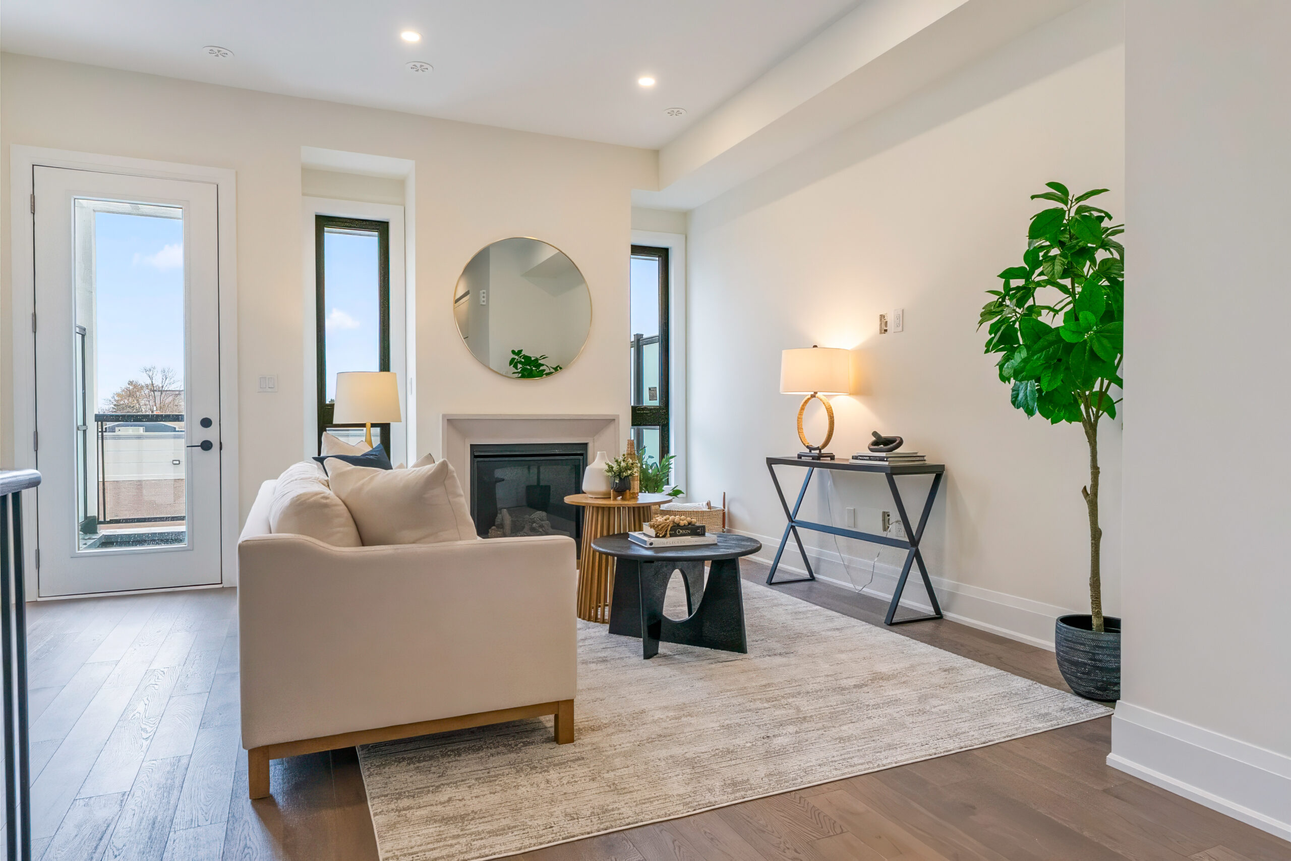 Modern living room with a fireplace, plants, and natural light