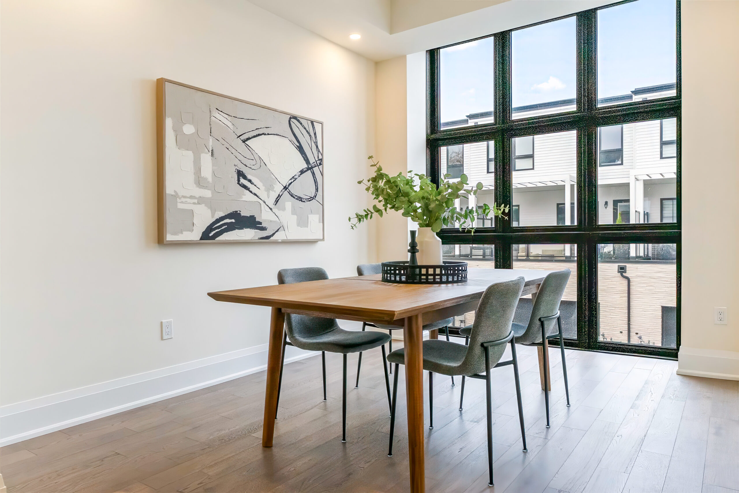 Modern dining area with a wooden table, chairs, and large windows