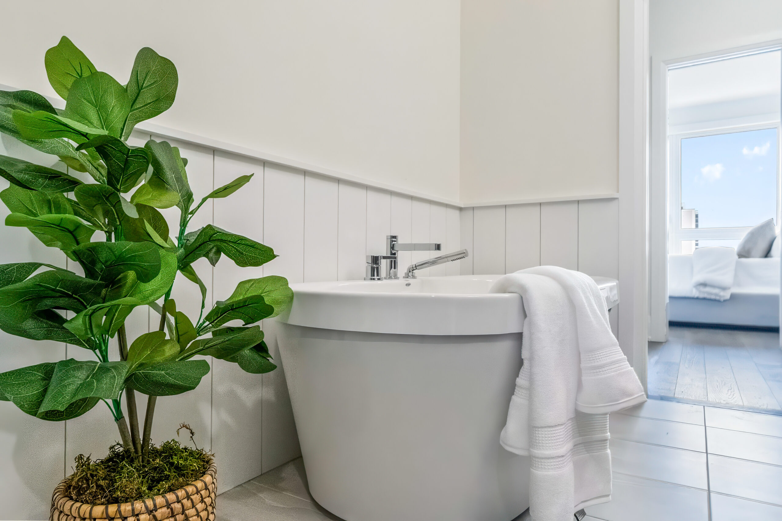 Modern bathroom featuring a freestanding tub and potted plant