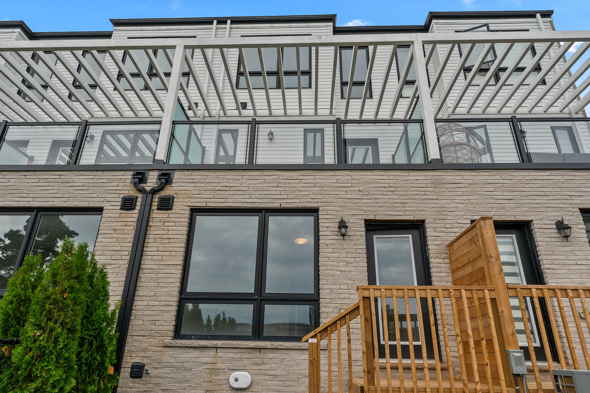 Modern townhouse exterior with large windows and wooden deck