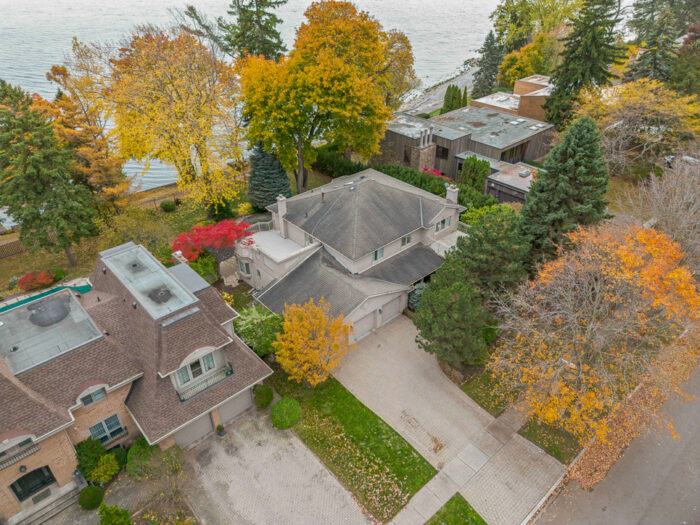 Aerial view of a residential area with autumn foliage and nearby lake