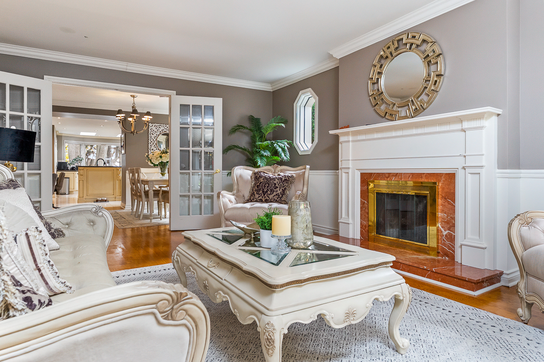 Elegant living room with a fireplace, decorative mirror, and stylish furniture