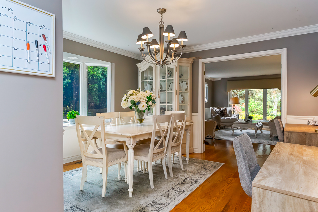 Elegant dining room with a chandelier, wooden table, and floral centerpiece