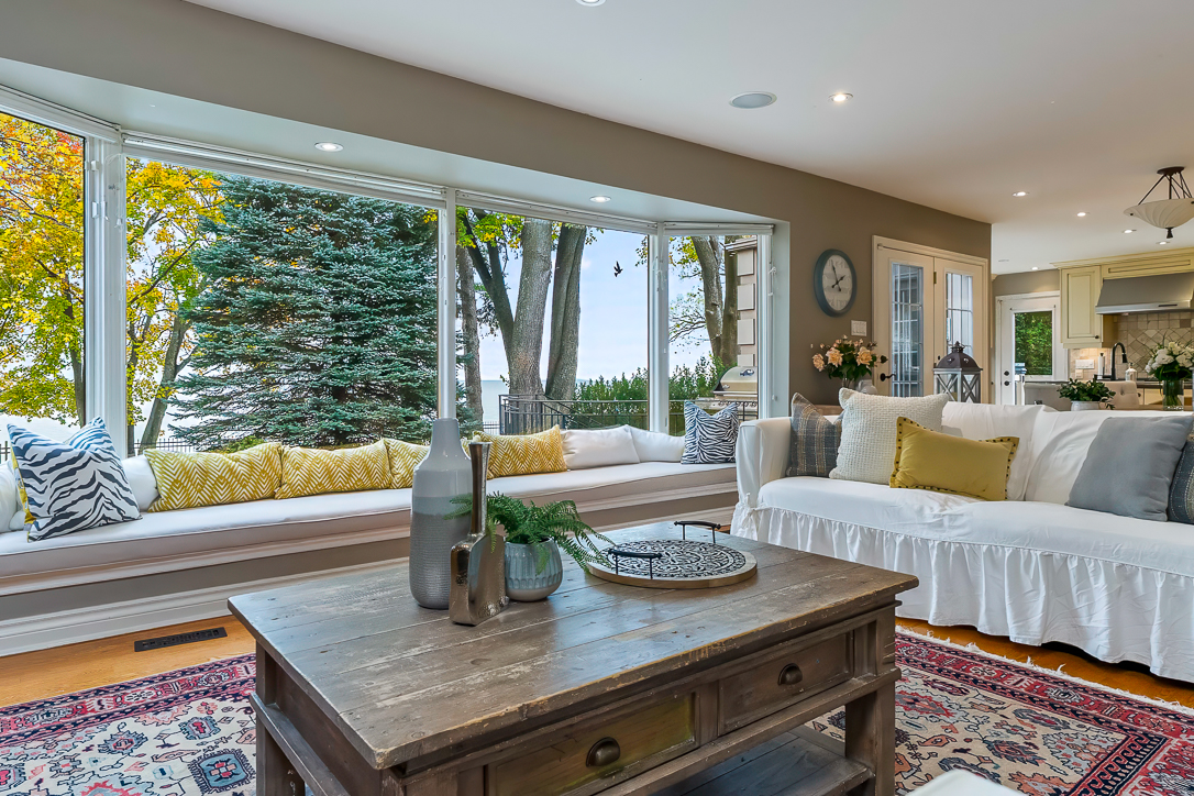 Cozy living room with large windows, plush seating, and decorative accents