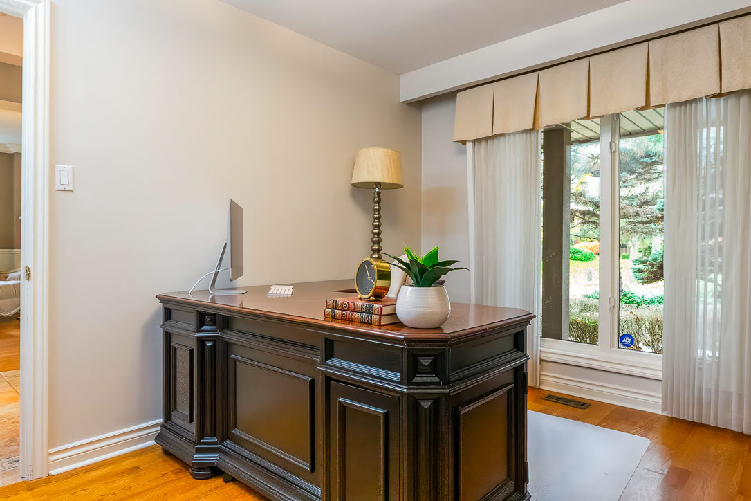 Elegant home office with dark wood desk and natural light from windows