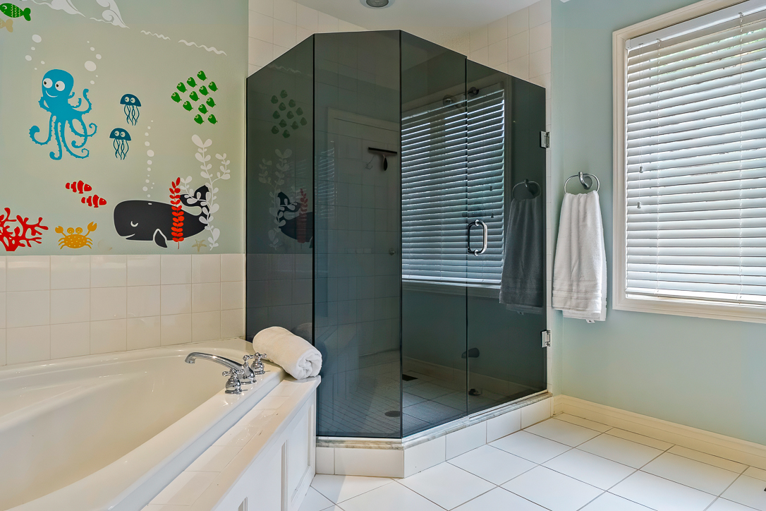 Modern bathroom featuring a glass shower and playful wall decals