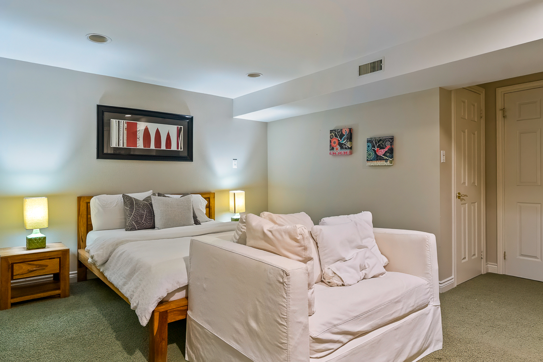 Cozy bedroom with a bed, armchair, and decorative wall art