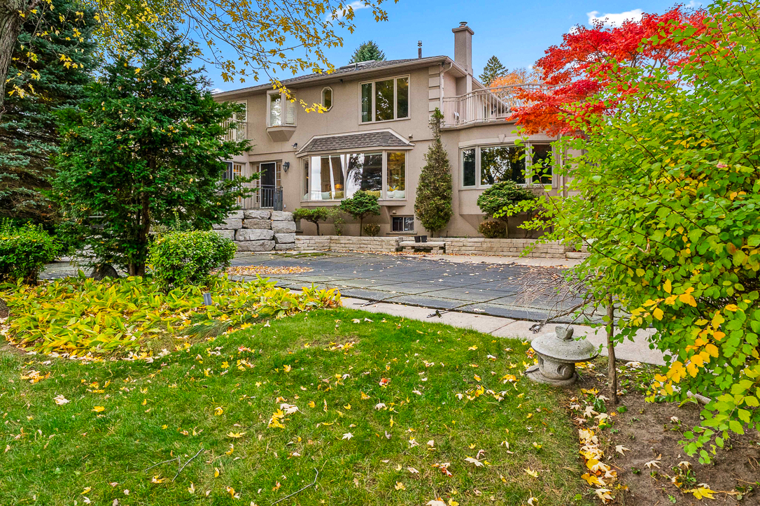 Elegant home with landscaped yard and colorful autumn foliage