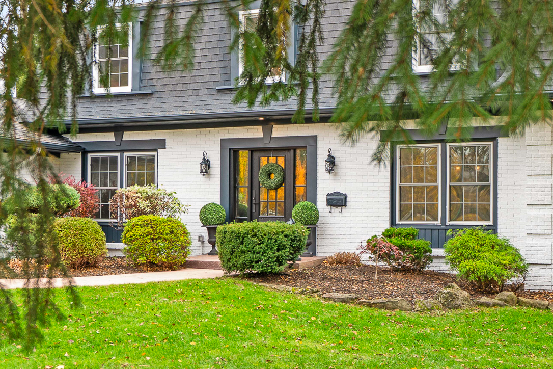 Charming home entrance with greenery and a decorative wreath on the door
